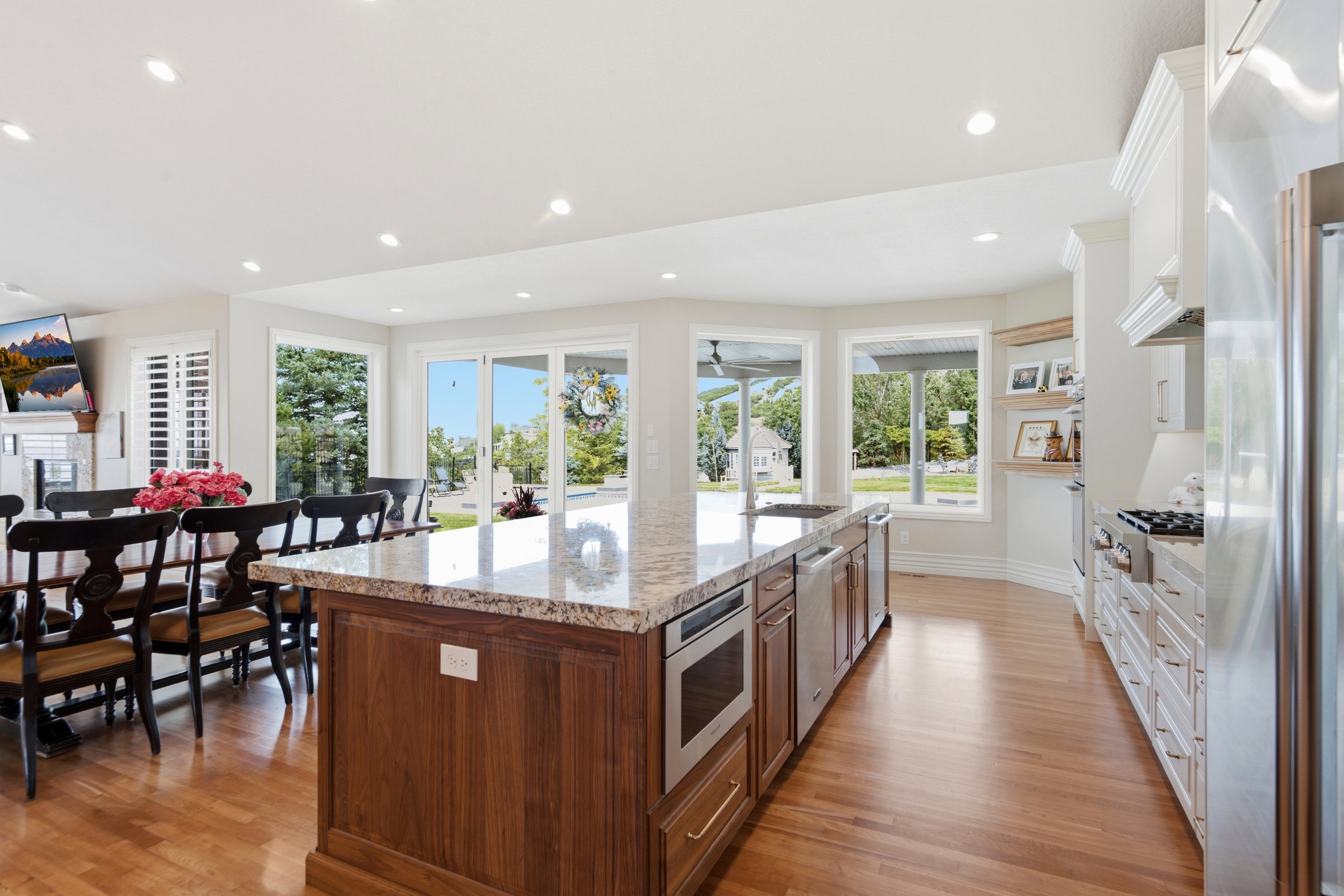Gourmet kitchen featuring a large wood-finish island with a stone-finish countertop, stainless steel appliances, recessed lighting, and hardwood flooring