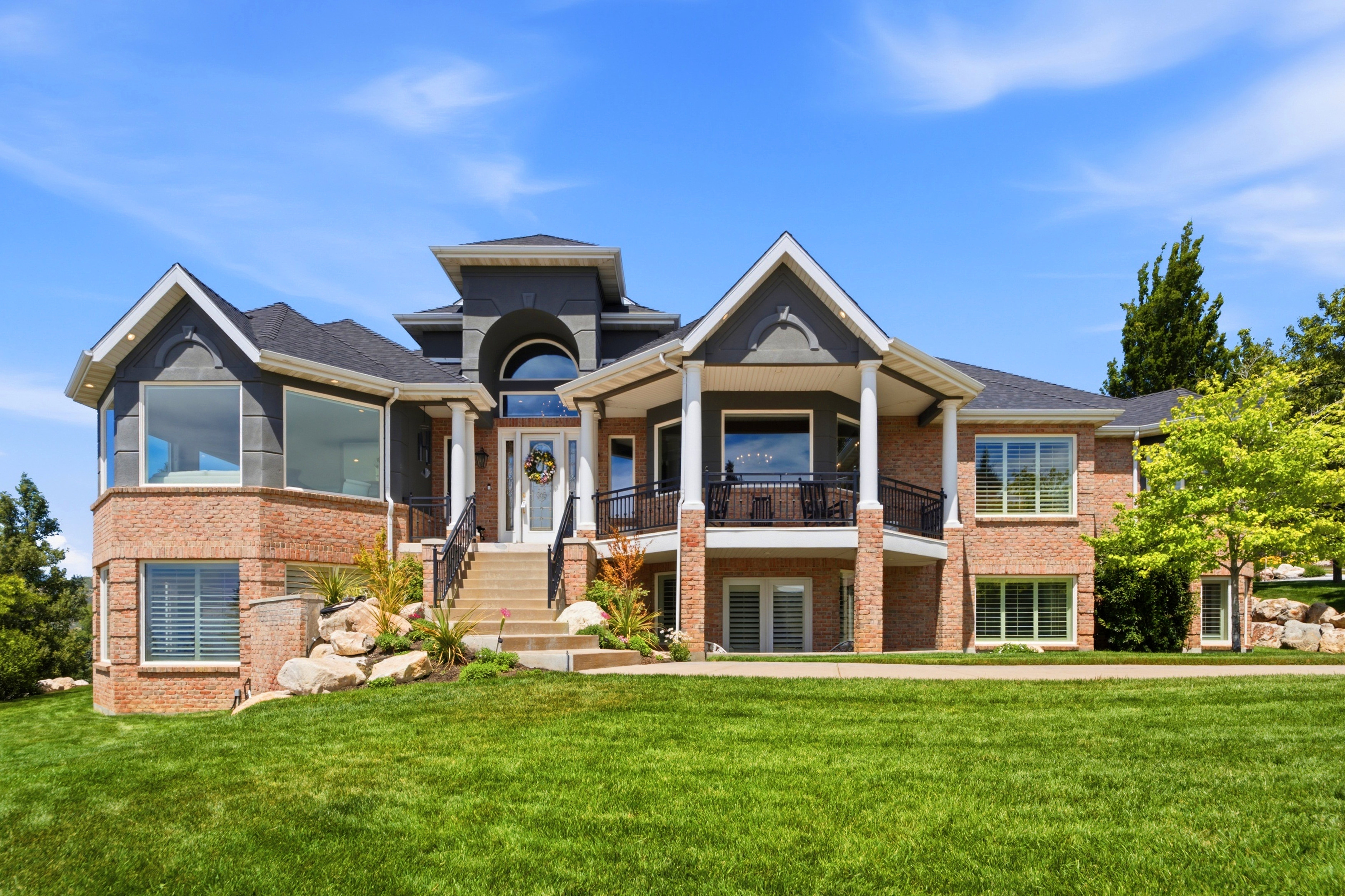 Brick and siding exterior featuring multiple gables and a prominent entrance with a semicircular transom window