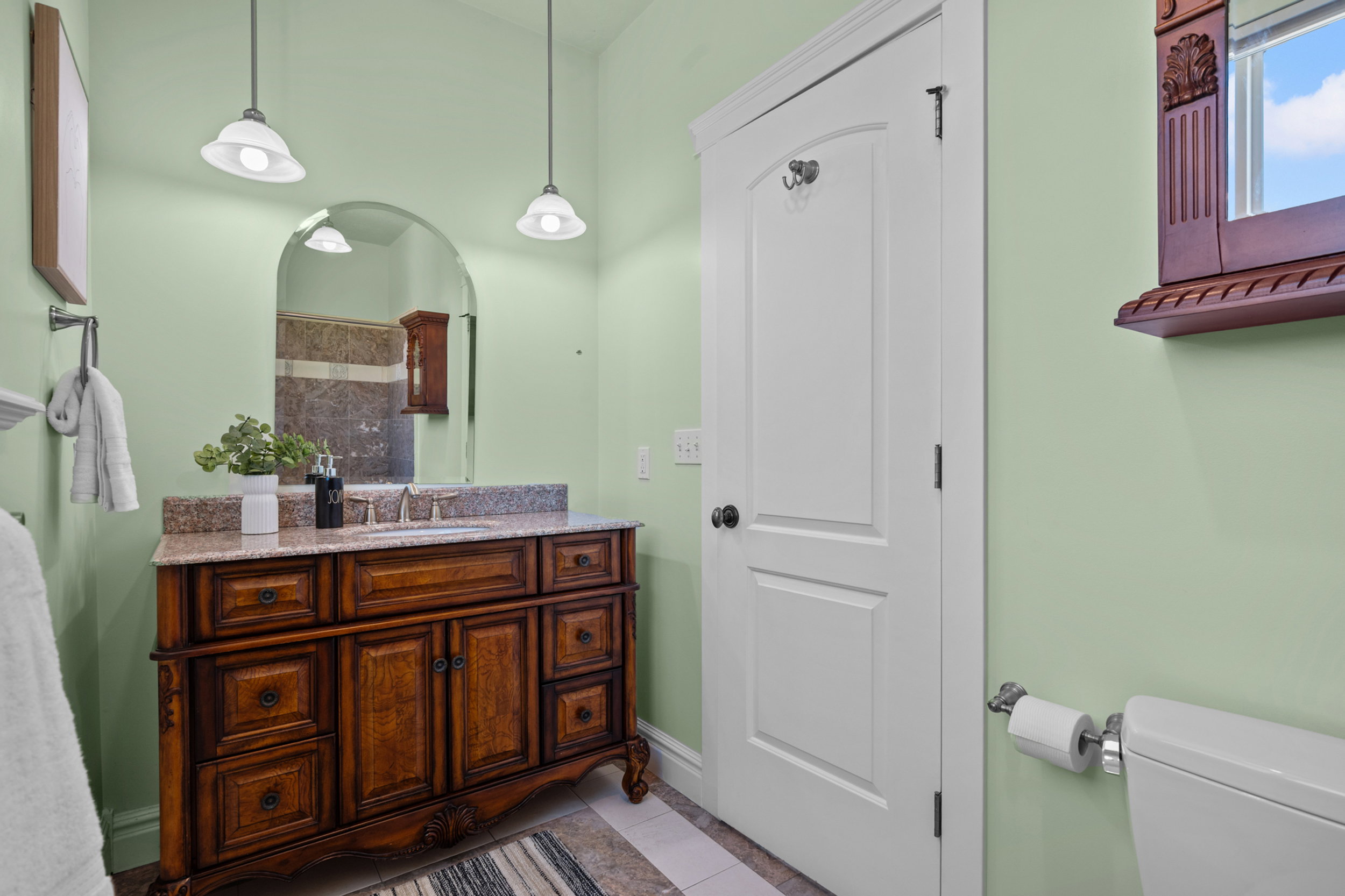 Vanity with an integrated sink, a granite countertop, and rich wood cabinetry