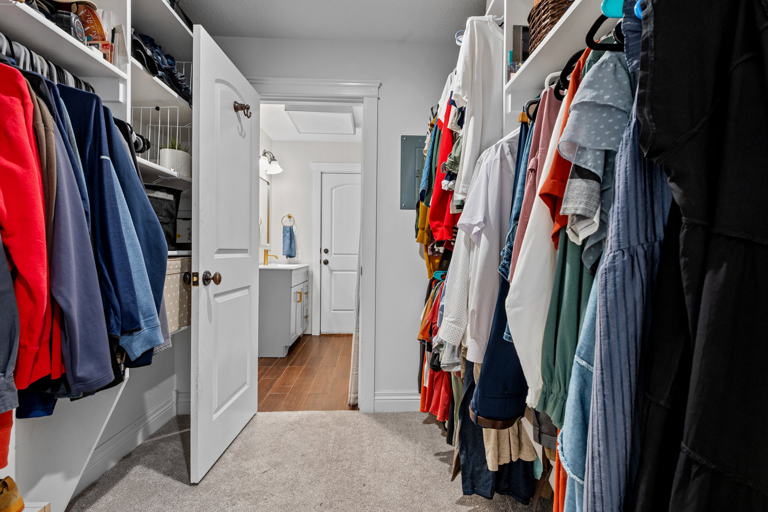 Spacious walk-in closet with carpet flooring and built-in shelving, providing ample storage