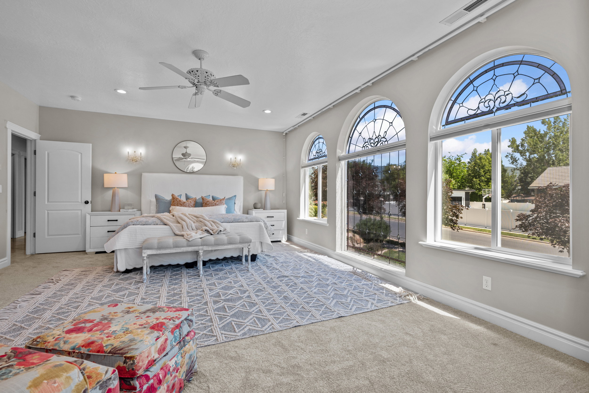 Spacious room featuring multiple arched windows with decorative stained glass accents