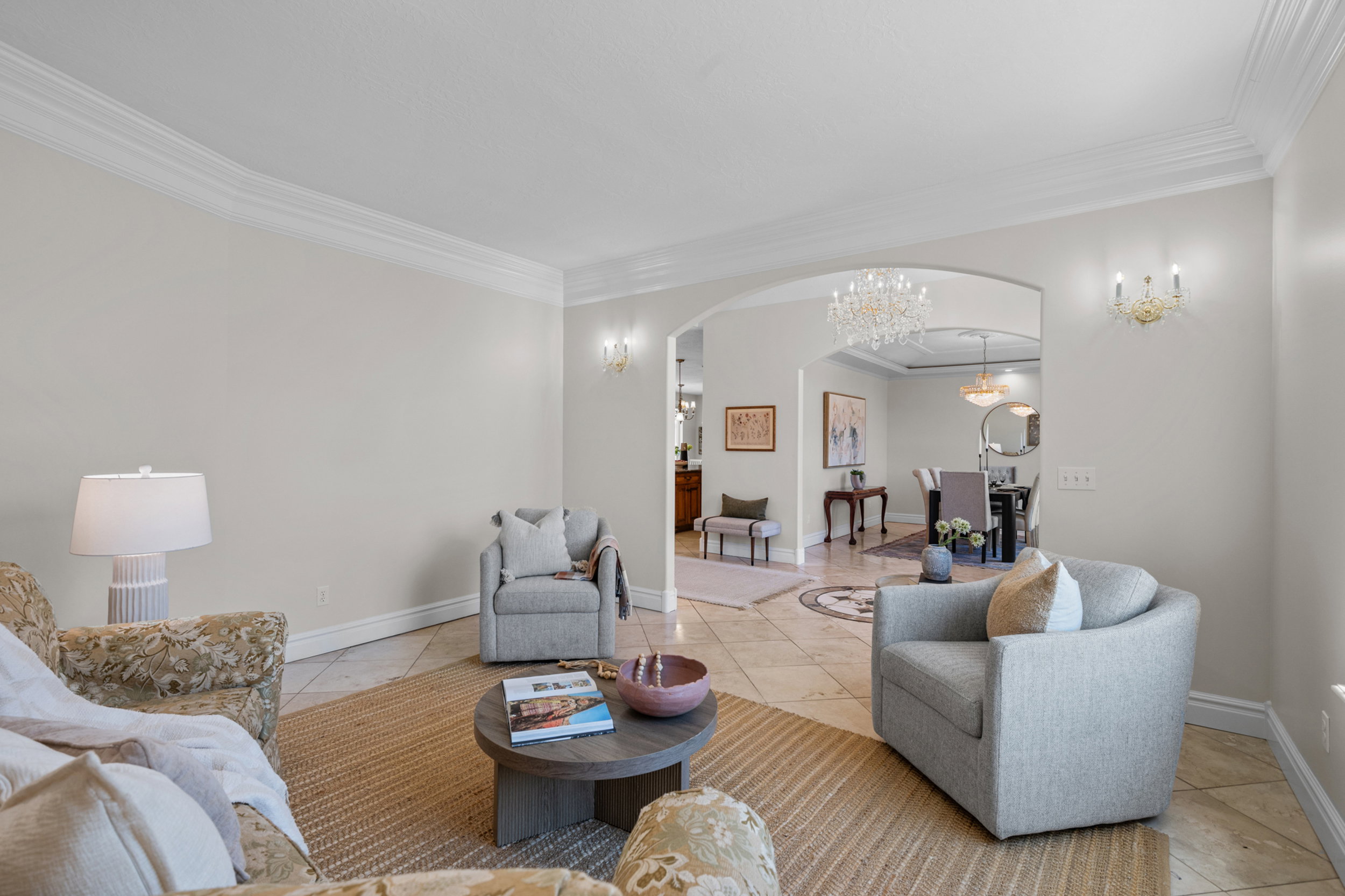 Archway entry to dining area, featuring crown molding, neutral wall tones