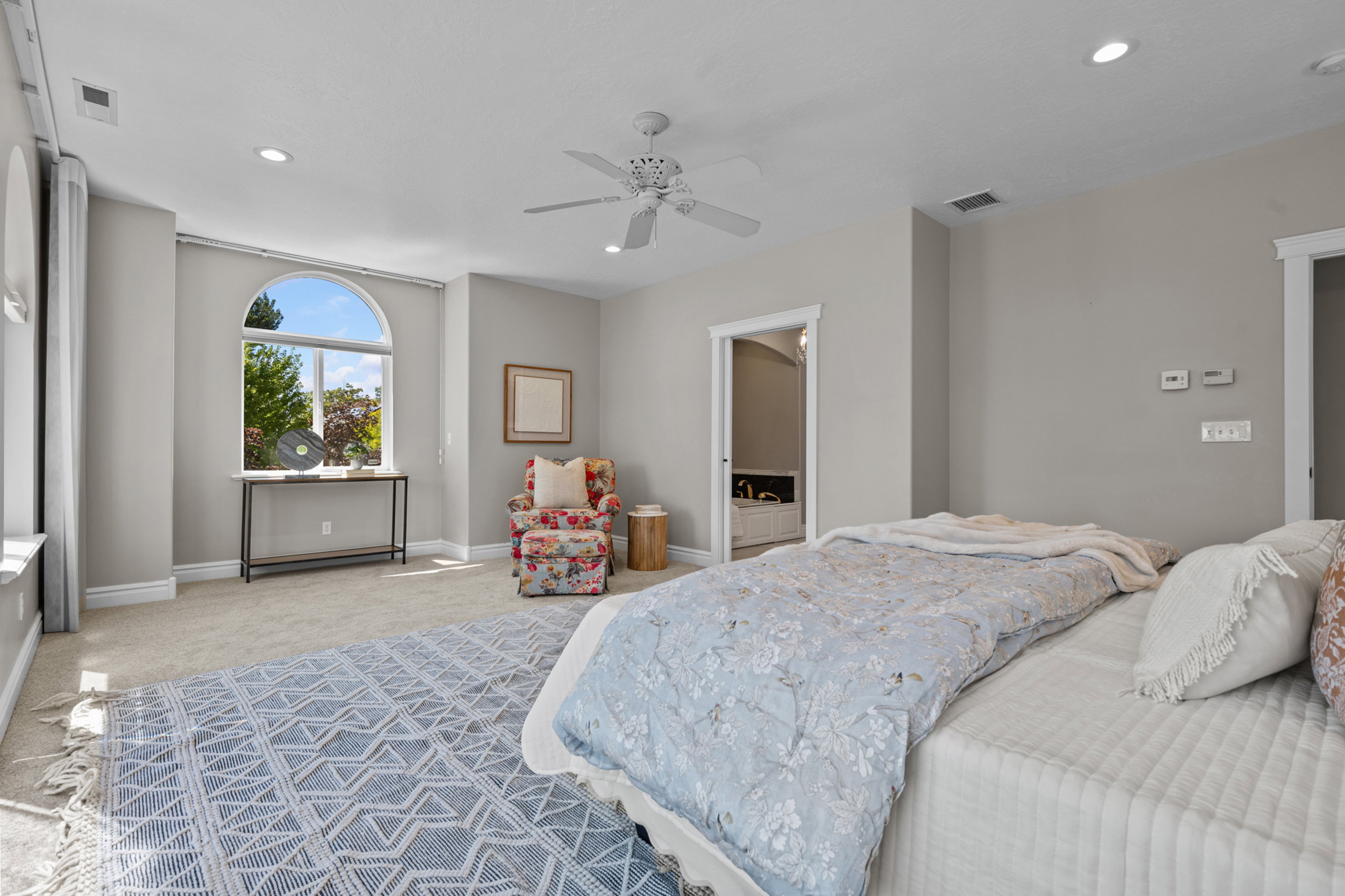 Spacious room featuring an arched window, recessed lighting, and a ceiling fan