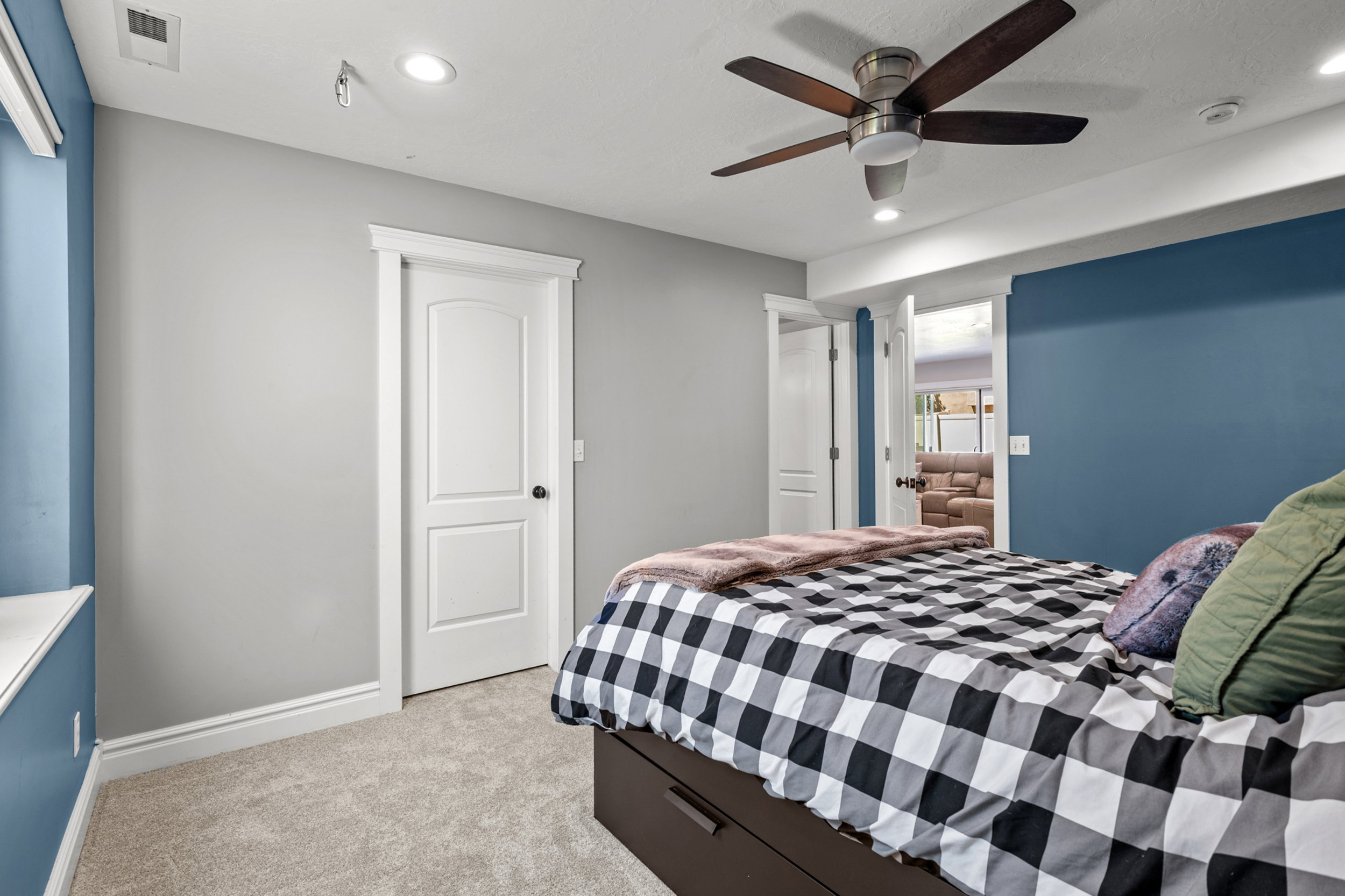 Room featuring soft gray and accent blue walls, recessed lighting, a ceiling fan with wood-finish blades, and neutral-toned carpeting