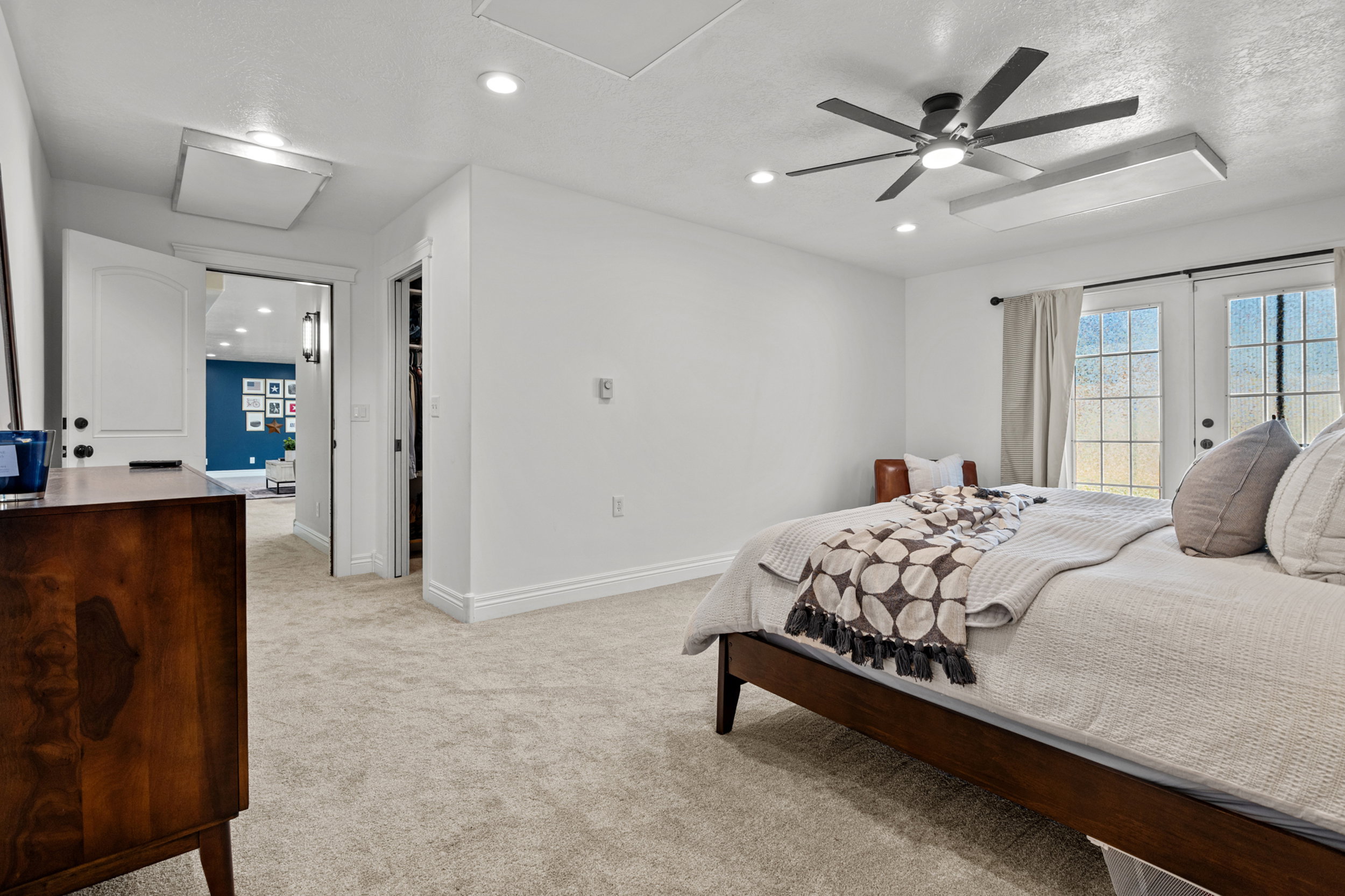 Plush carpeted flooring and recessed lighting illuminate this bright space