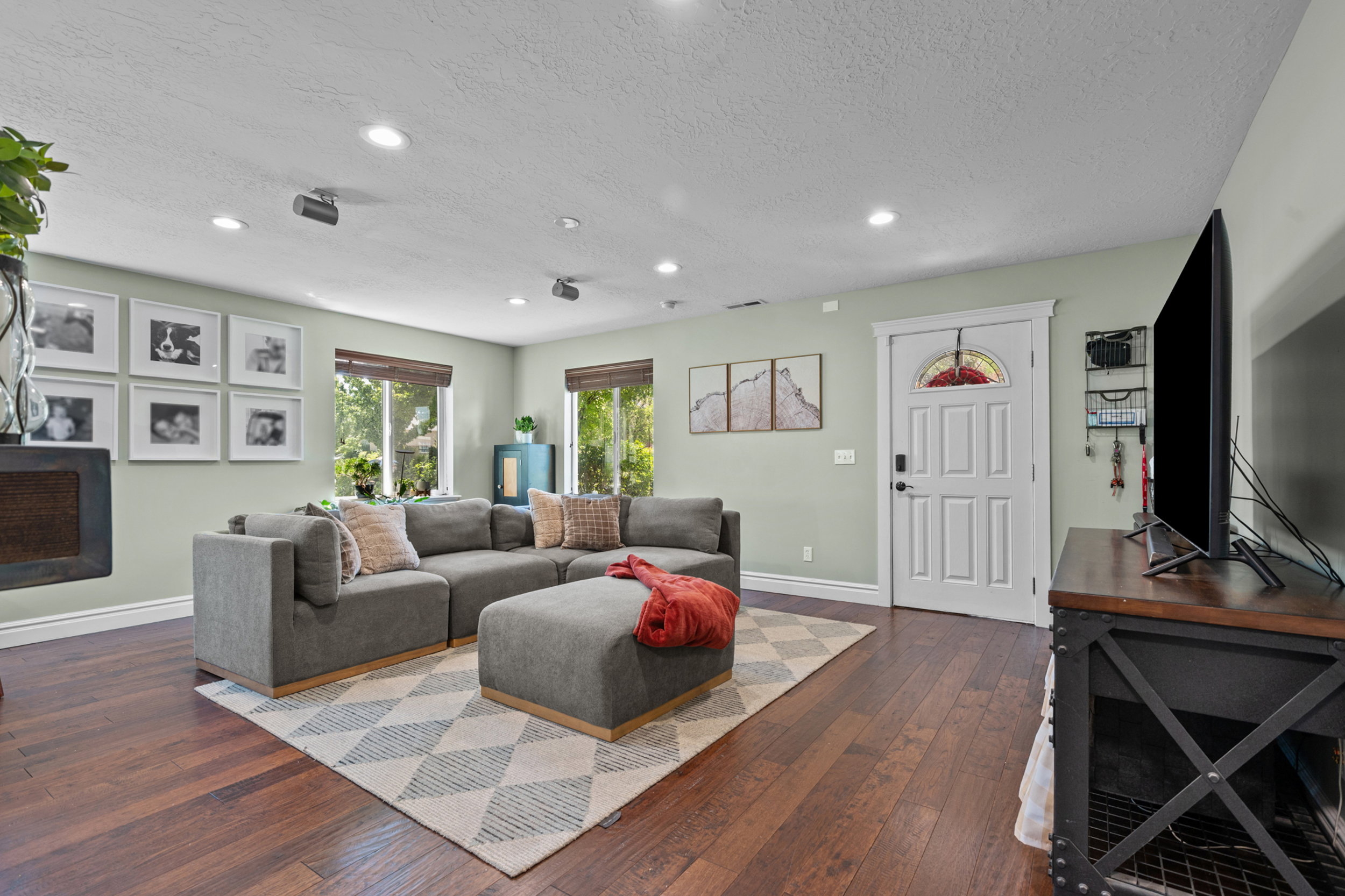 Living area featuring wood-finish flooring, recessed lighting, and multiple windows