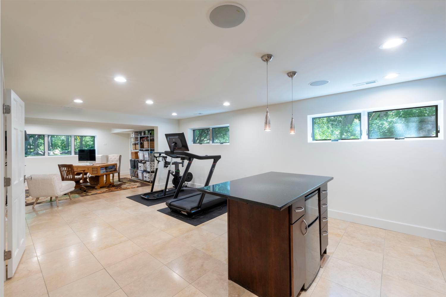 Spacious room with large format tile flooring and multiple recessed lighting fixtures