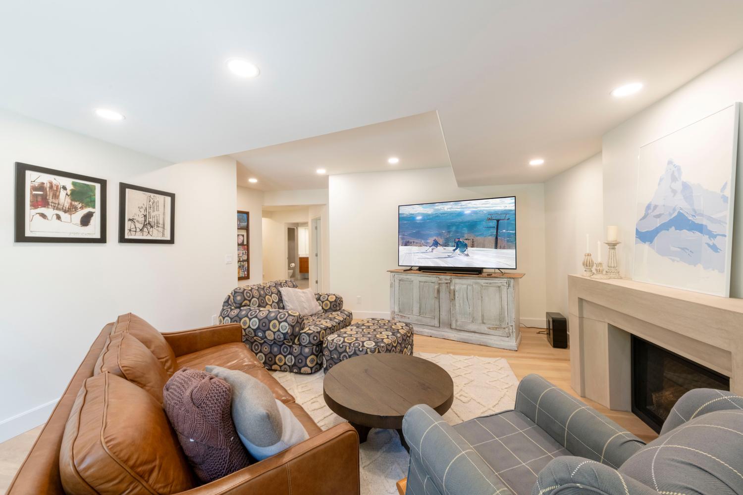 Recessed lighting illuminating a spacious room with light wood-finish flooring