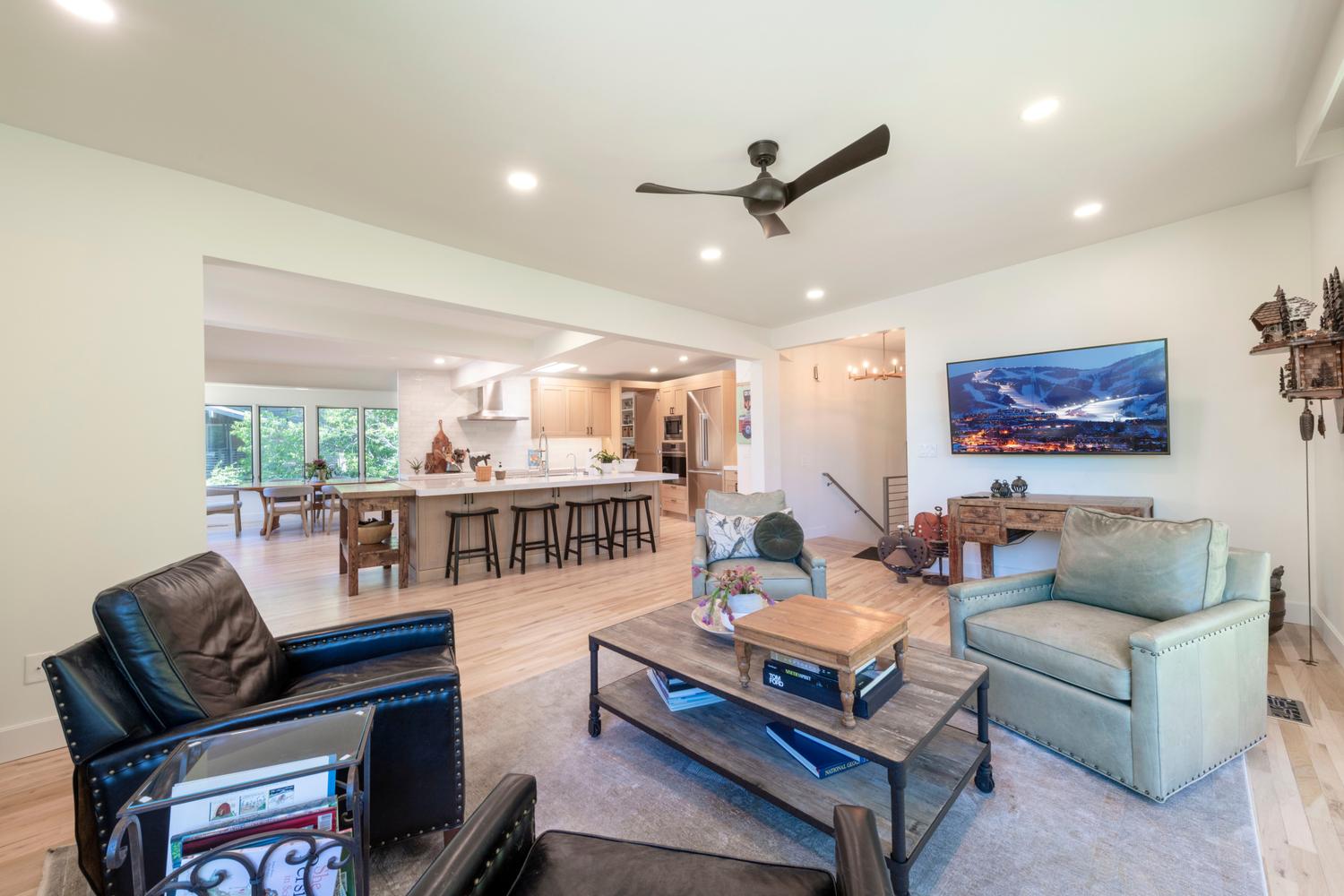 Open-concept living area featuring light wood-finish flooring, recessed lighting, and a contemporary ceiling fan