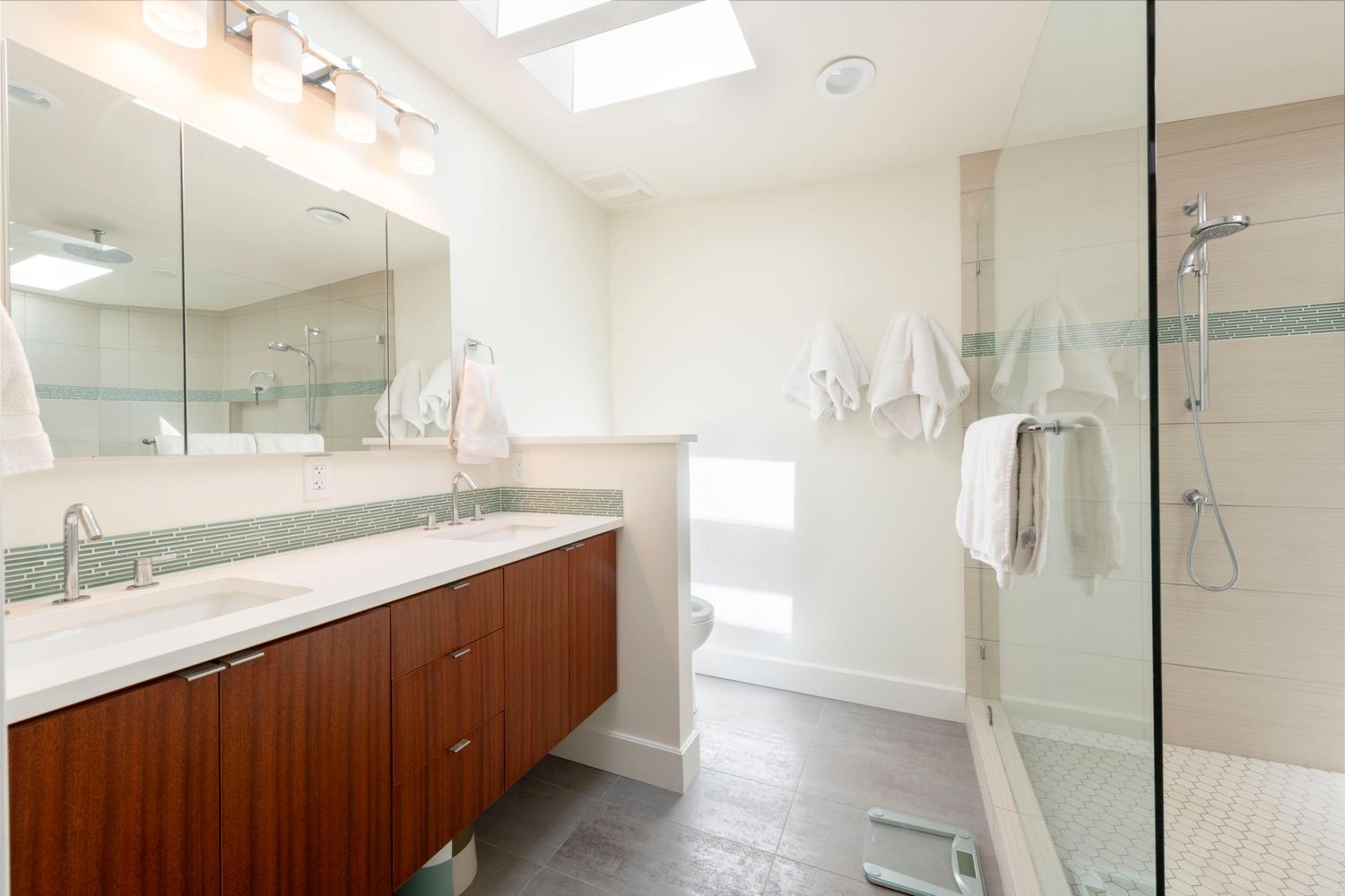 Bathroom featuring a dual vanity with wood-finish cabinetry, white countertops, and undermount sinks