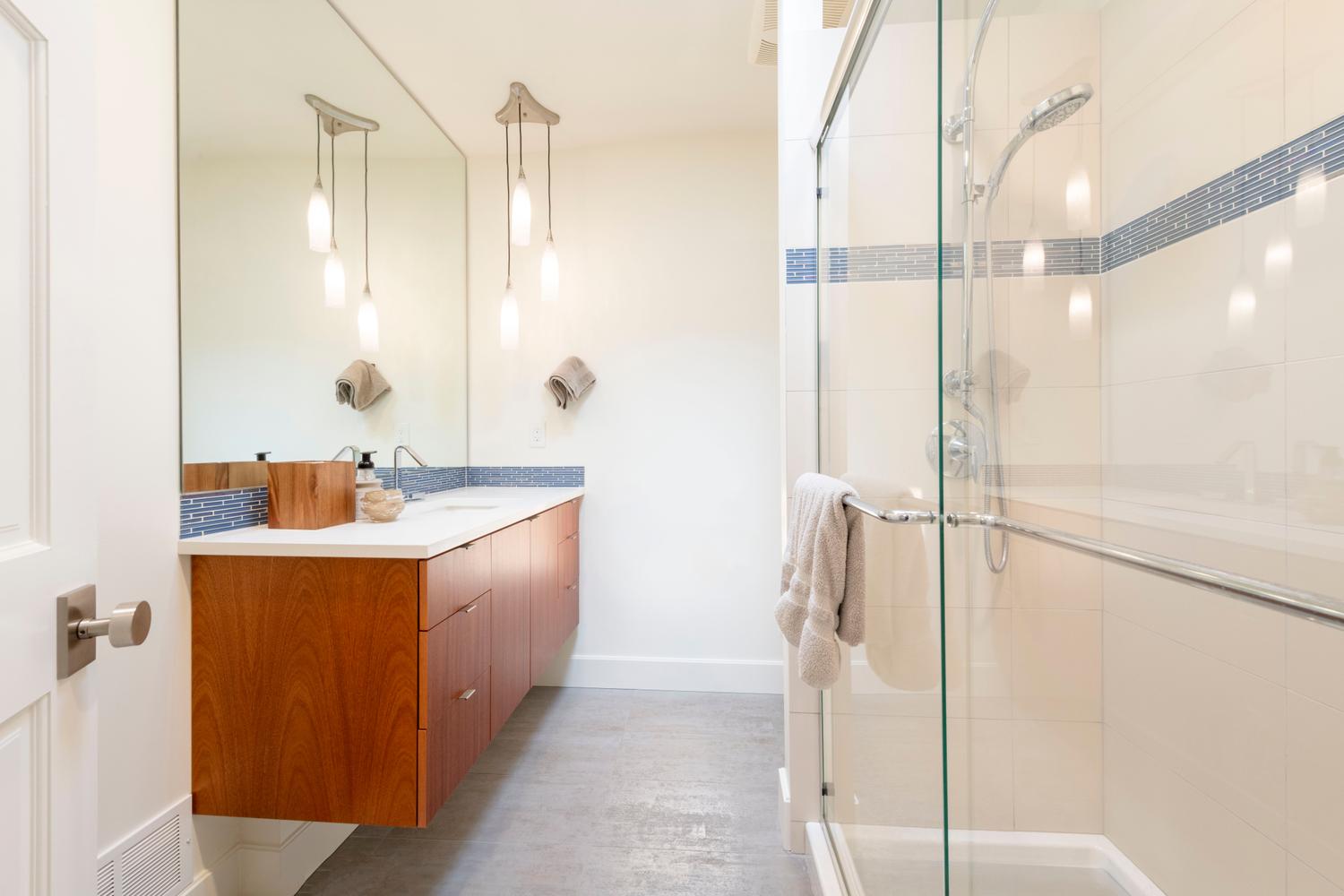 Floating wood-finish vanity with a white countertop and rectangular sink