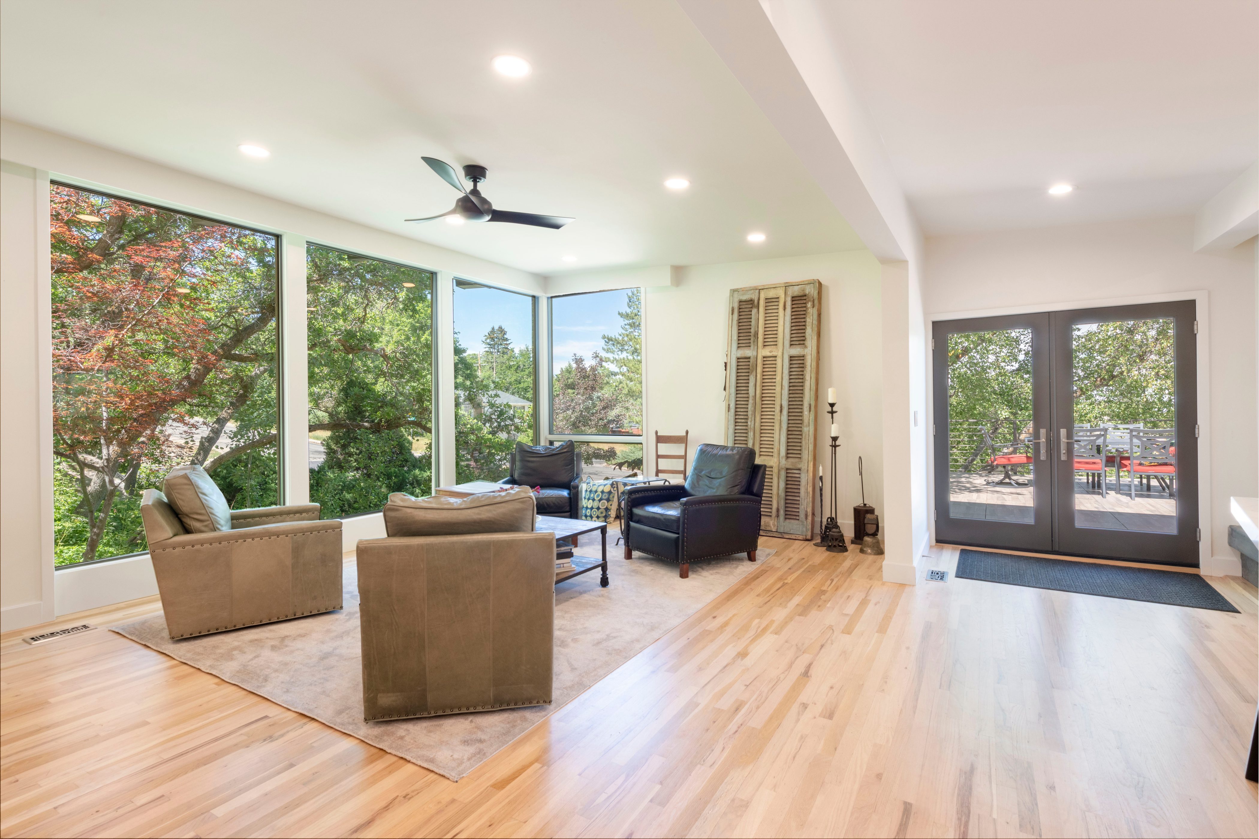 Living area with expansive floor-to-ceiling windows, light wood-finish flooring, recessed lighting, and a ceiling fan