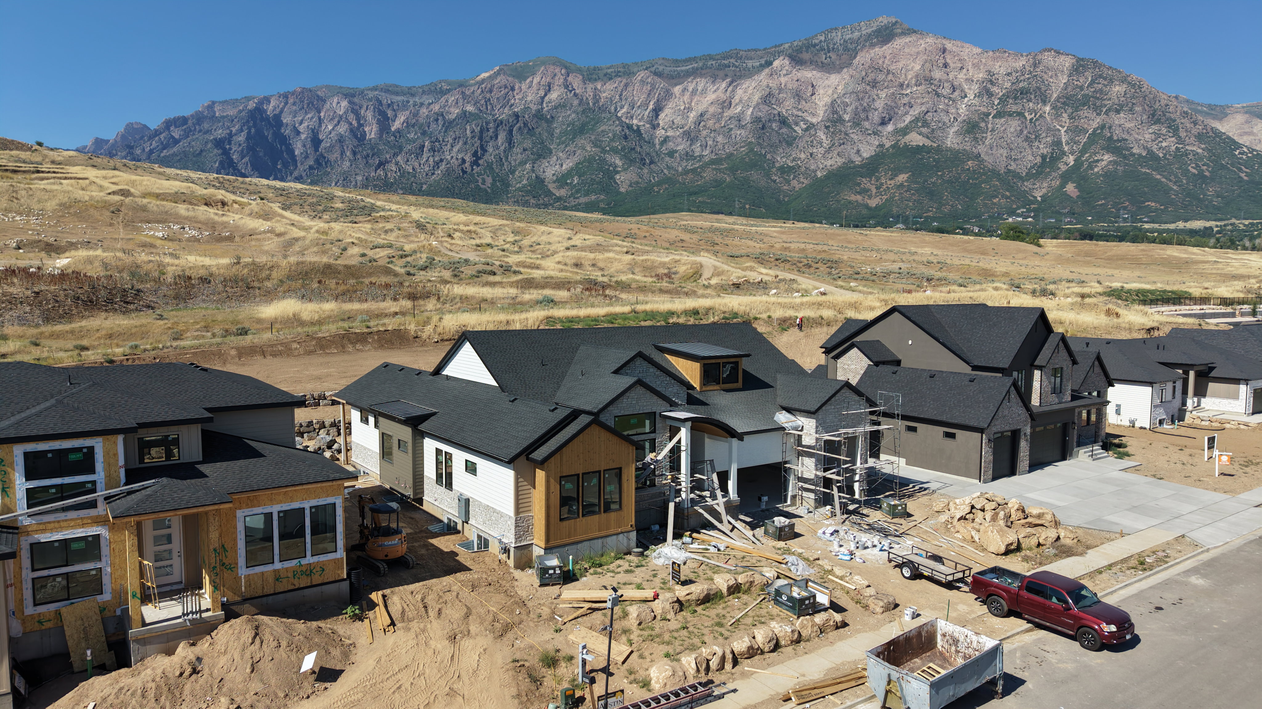 Newly constructed residence featuring a contemporary facade with a dark shingle roof, light-colored siding, and dark trim accents