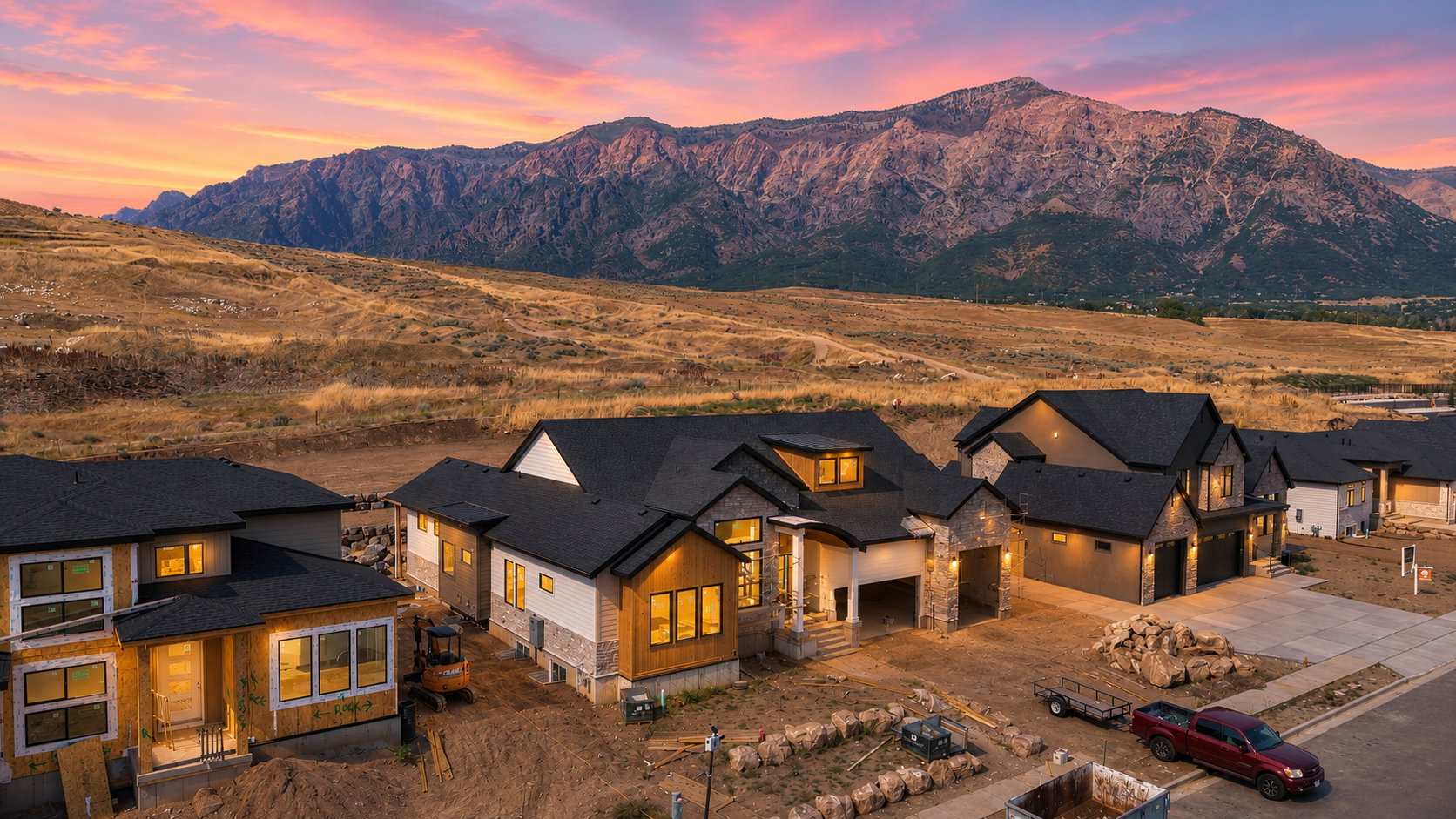 New construction homes featuring multi-tonal exteriors with natural stone accents, dark roofing, and multiple garage bays