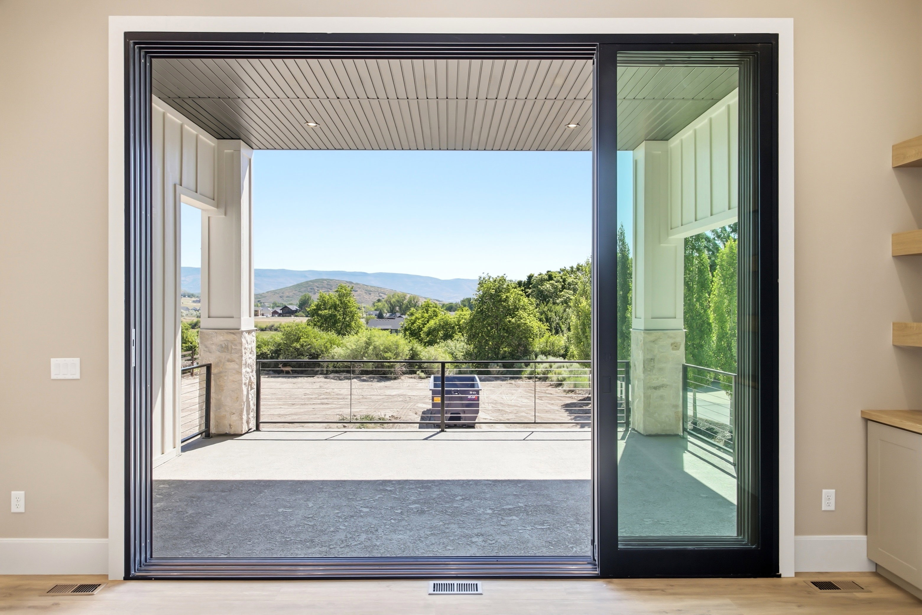 Expansive sliding glass doors opening to a covered patio