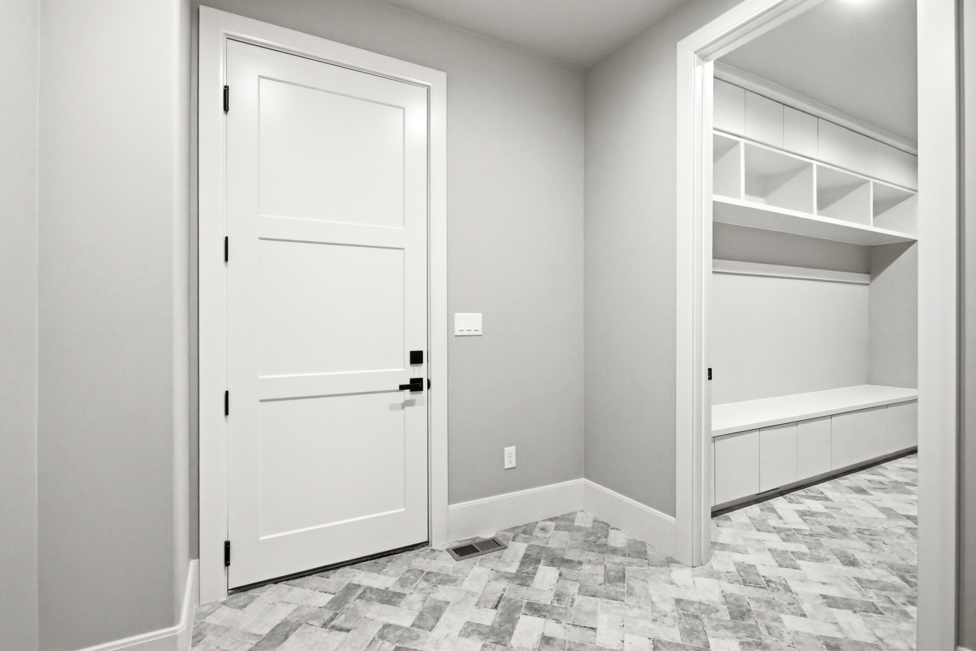 Dedicated mudroom space featuring built-in cabinetry, open shelving, and a bench with integrated storage