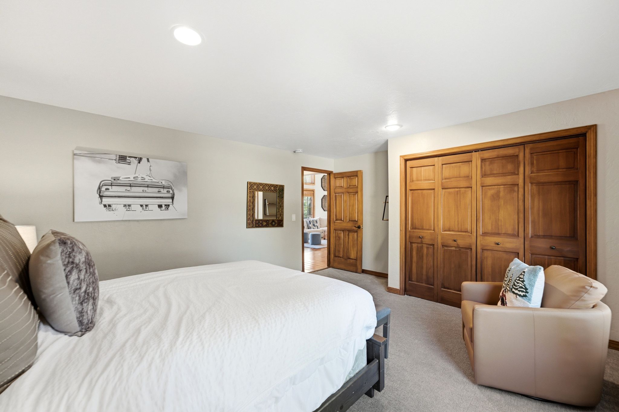 Spacious room featuring light neutral wall paint, recessed lighting, wood-finish bi-fold closet doors, and carpet flooring