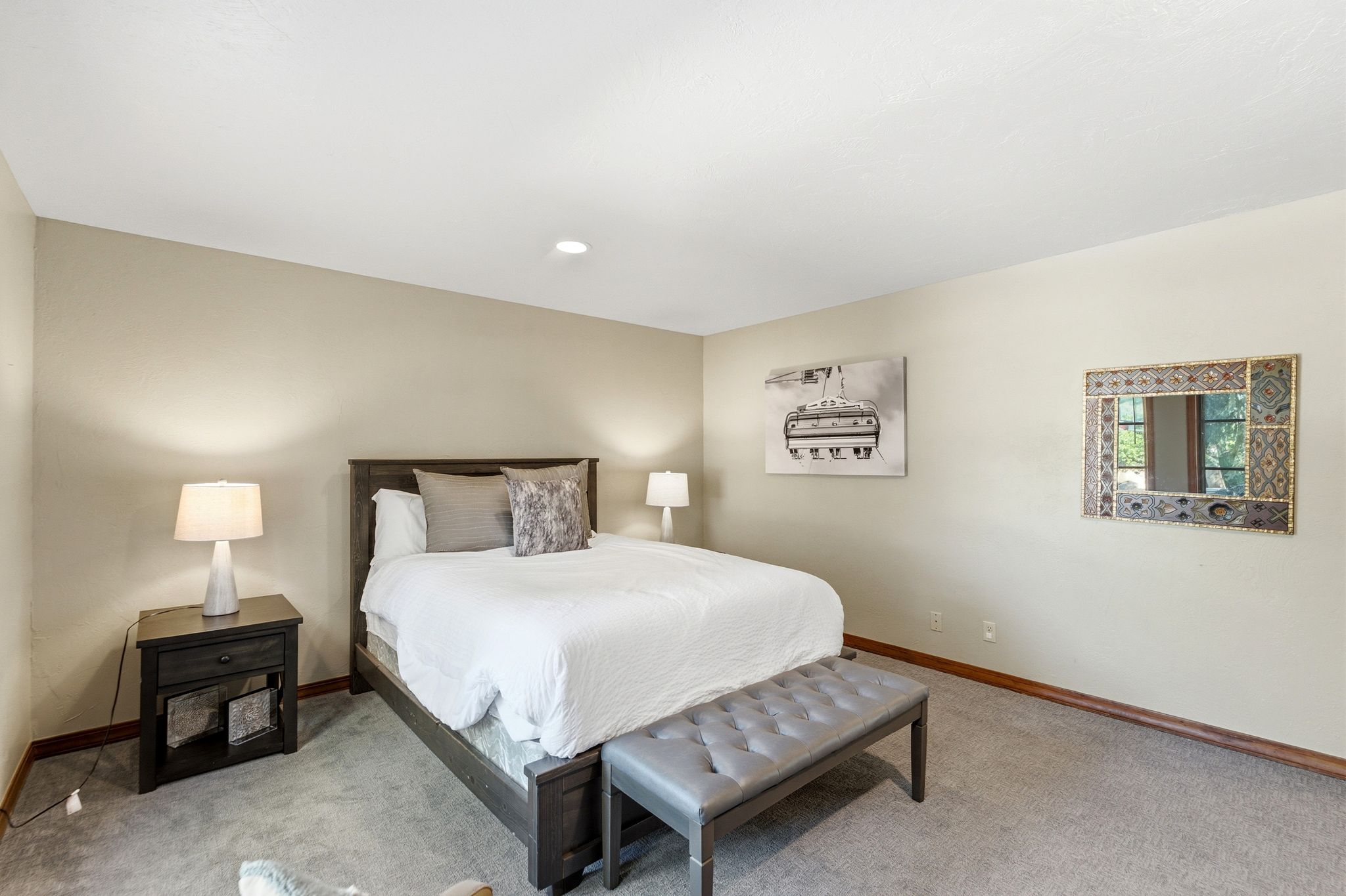 Spacious bedroom featuring neutral wall tones, recessed lighting, and ample natural light