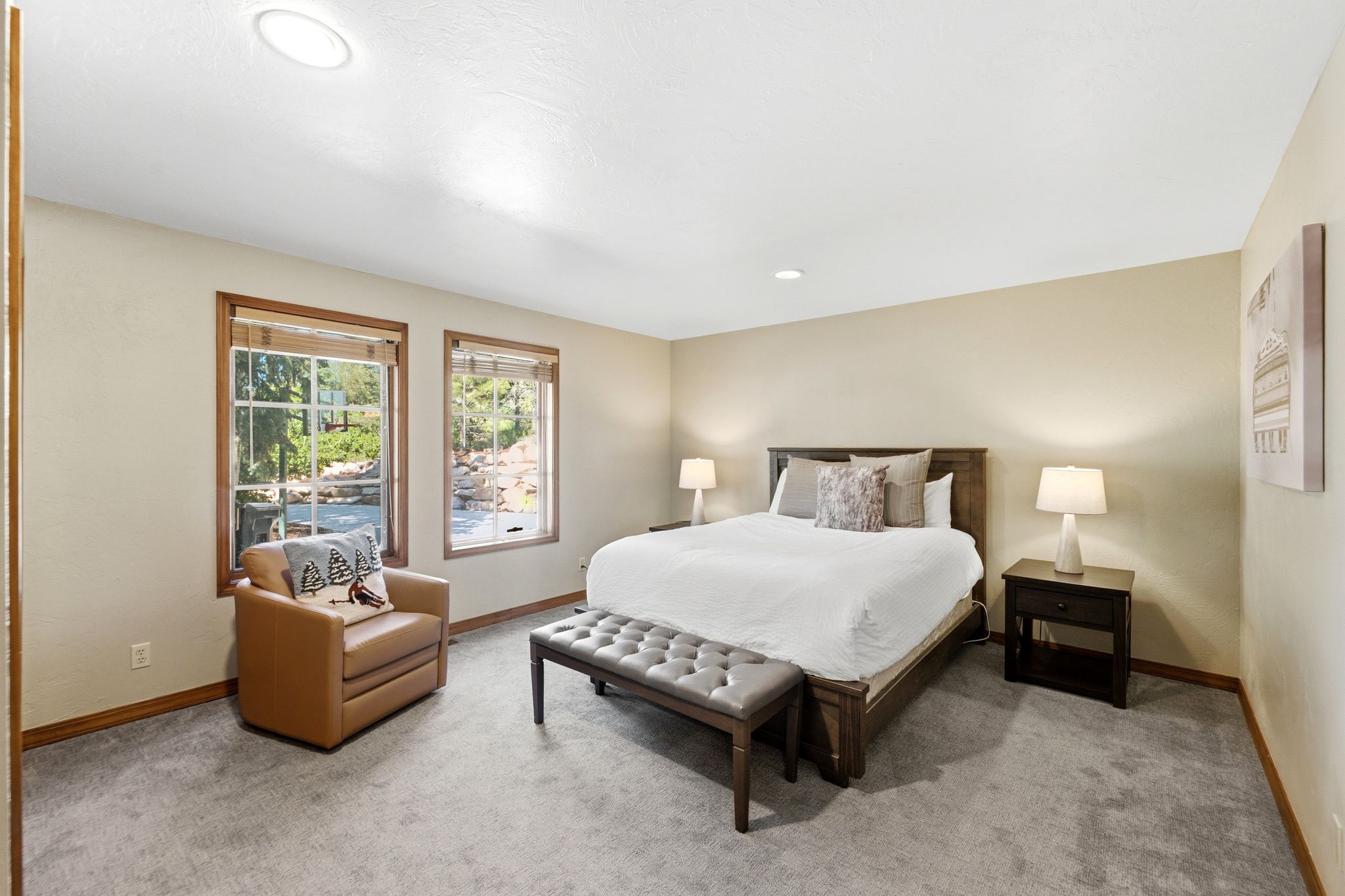 Carpeted room featuring two windows with wood-trim framing, recessed lighting, and a neutral wall color