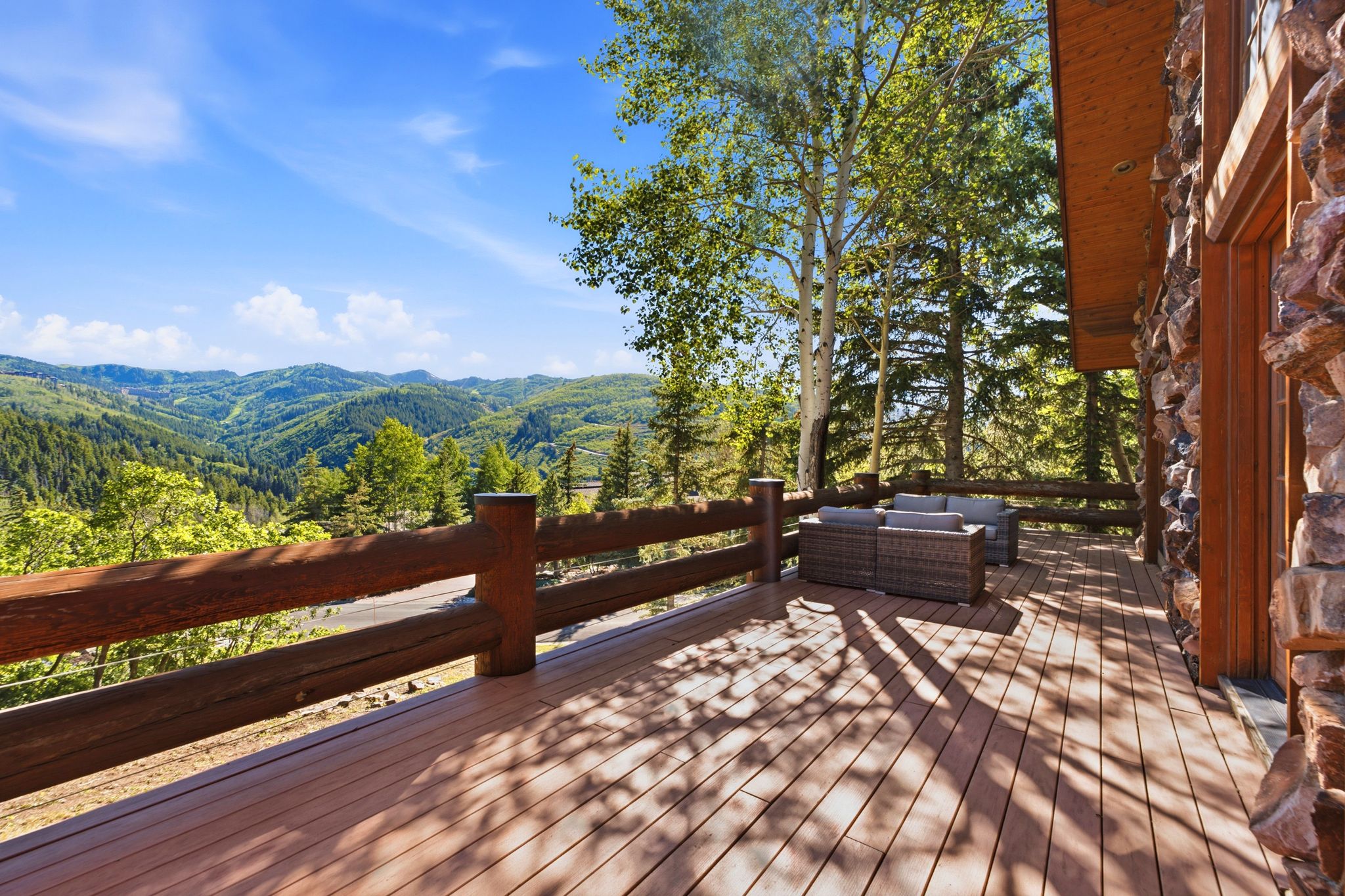 Expansive outdoor deck featuring wood-finish decking and a robust log railing