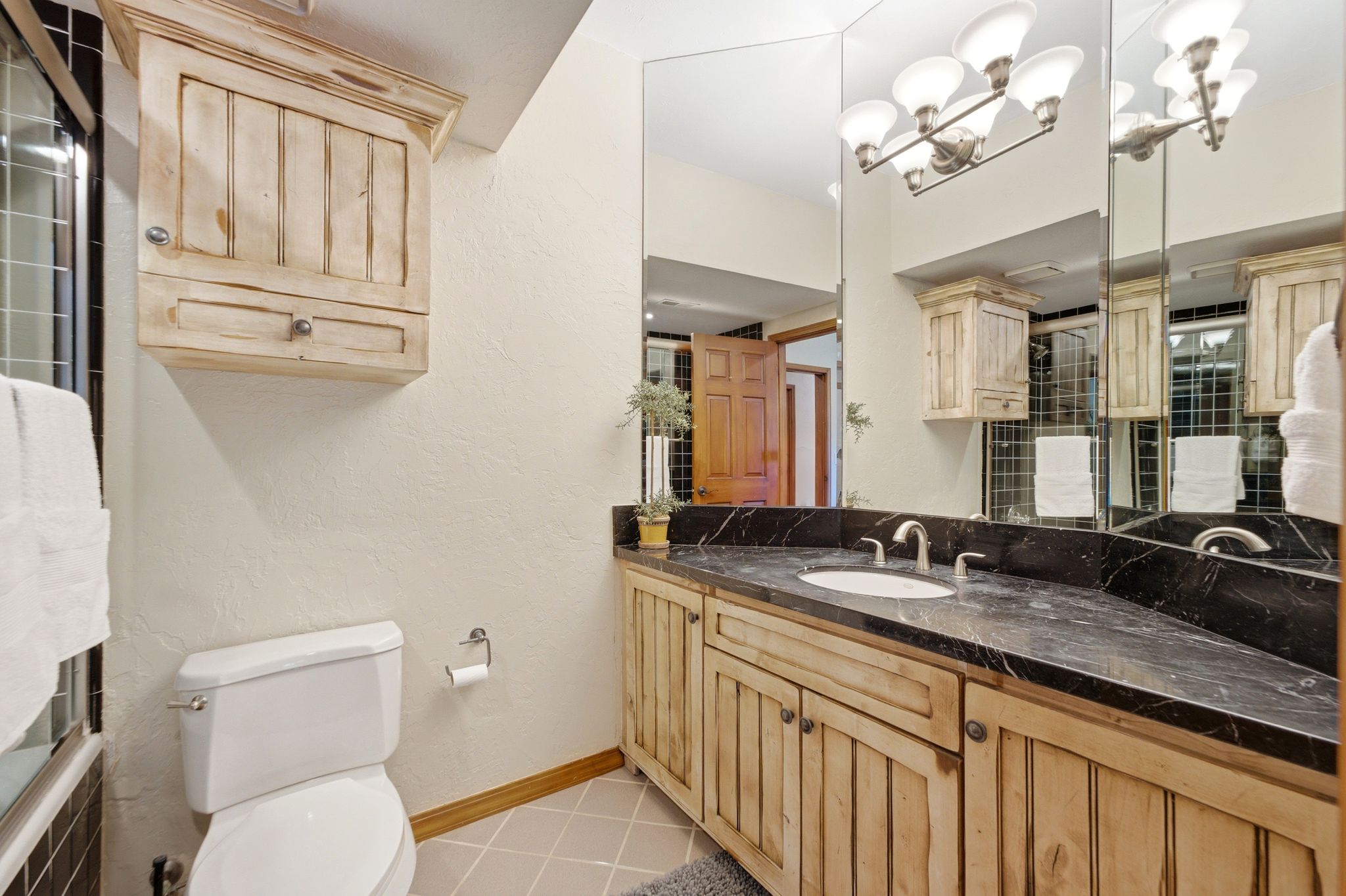 Bathroom featuring a dark stone countertop, an integrated sink, and a rustic wood-finish vanity