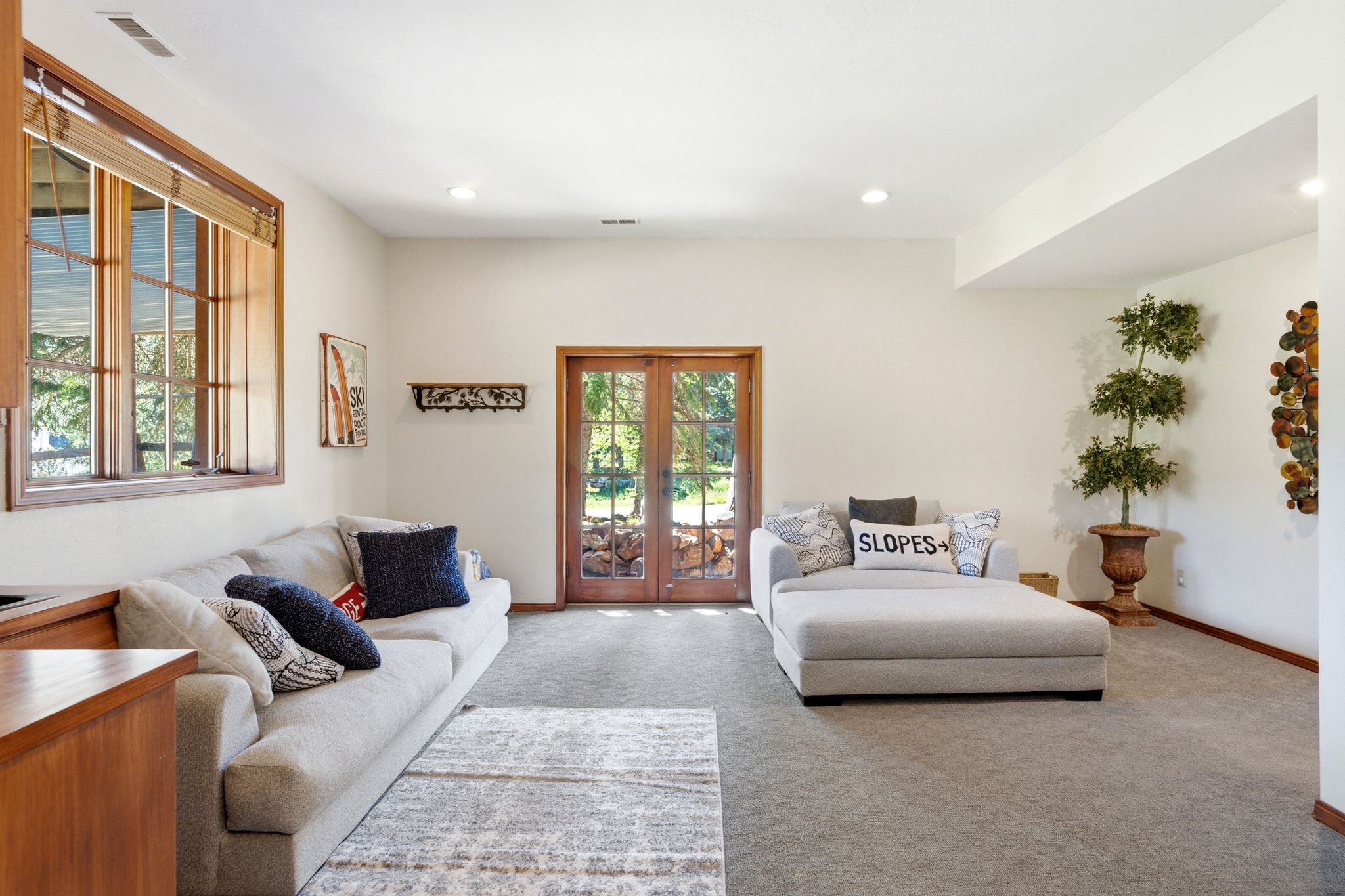 Spacious living area featuring light-toned walls and recessed lighting