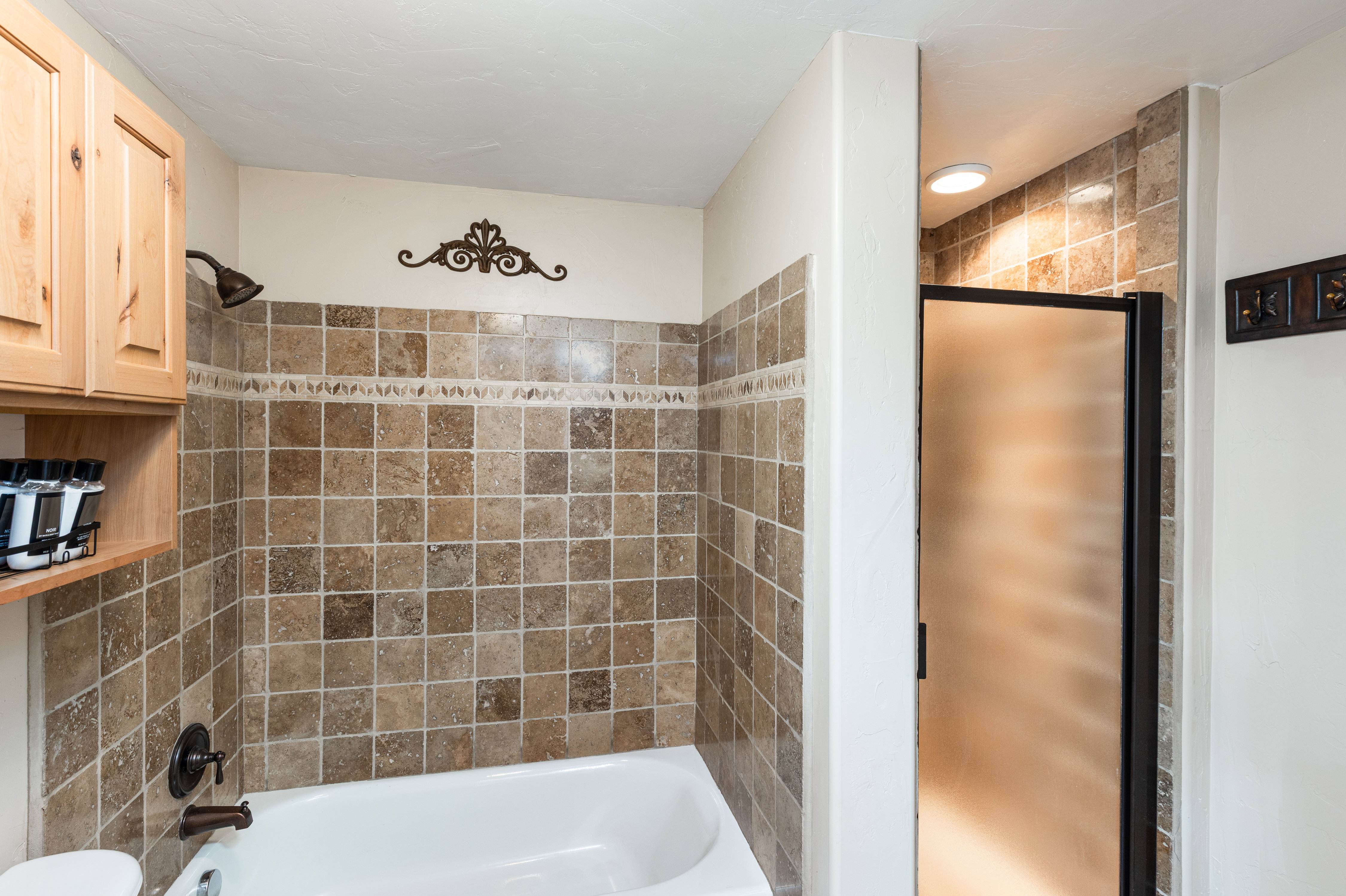 Bathroom featuring a tiled shower/tub combination with a dark bronze showerhead and faucet
