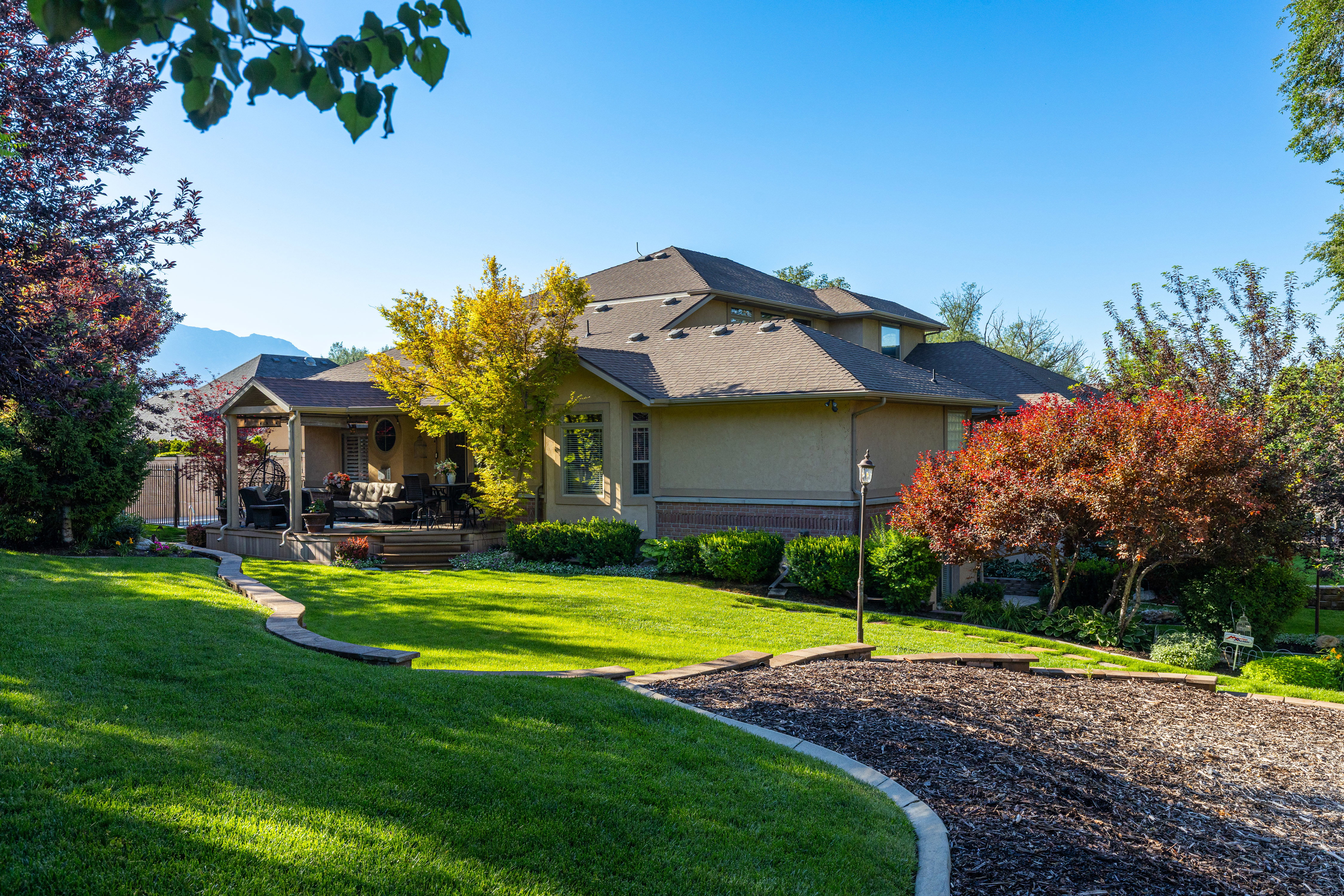 Expansive manicured lawn with mature trees and landscaping