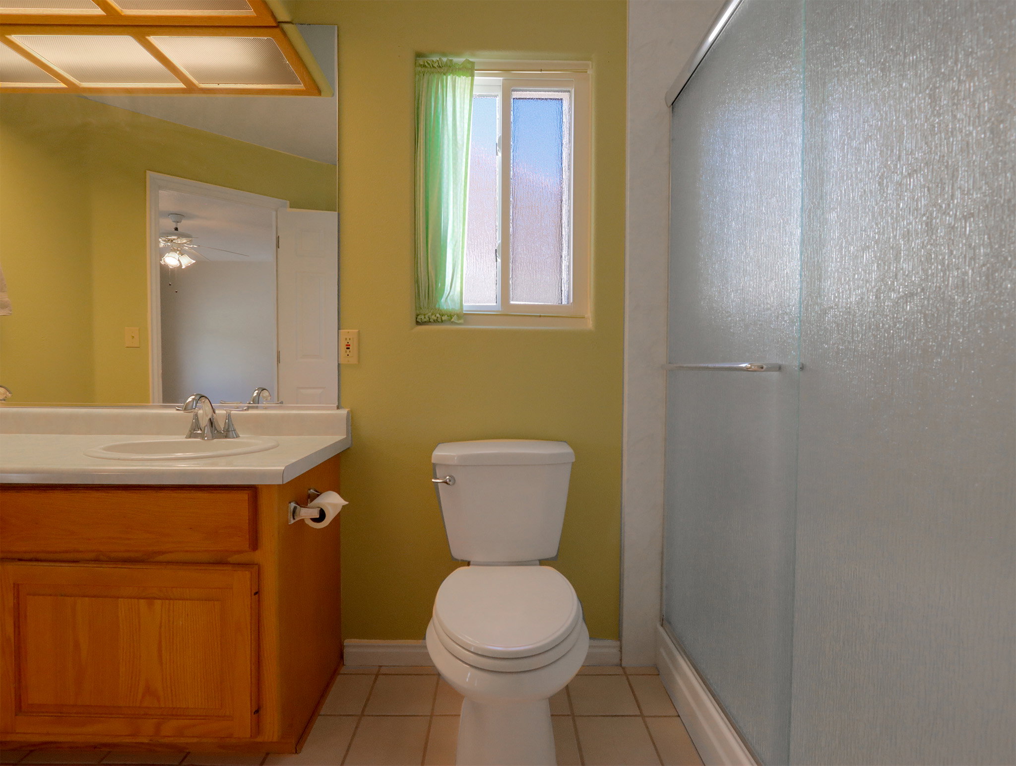 Bathroom featuring a single vanity with wood cabinetry, a white countertop, and a recessed sink