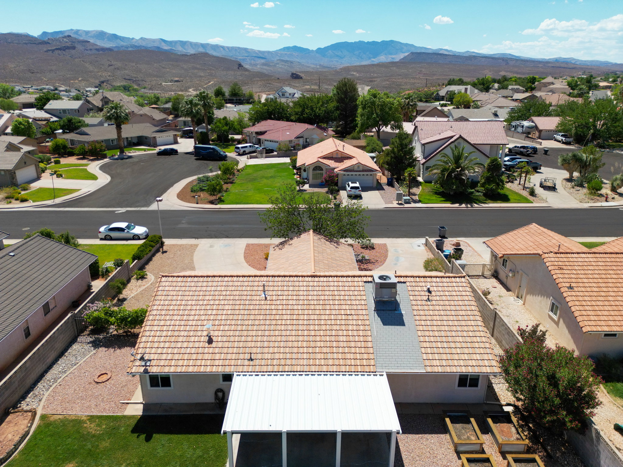 Property featuring a light-colored tile roof, a central HVAC unit on the roof, and a screened-in patio area