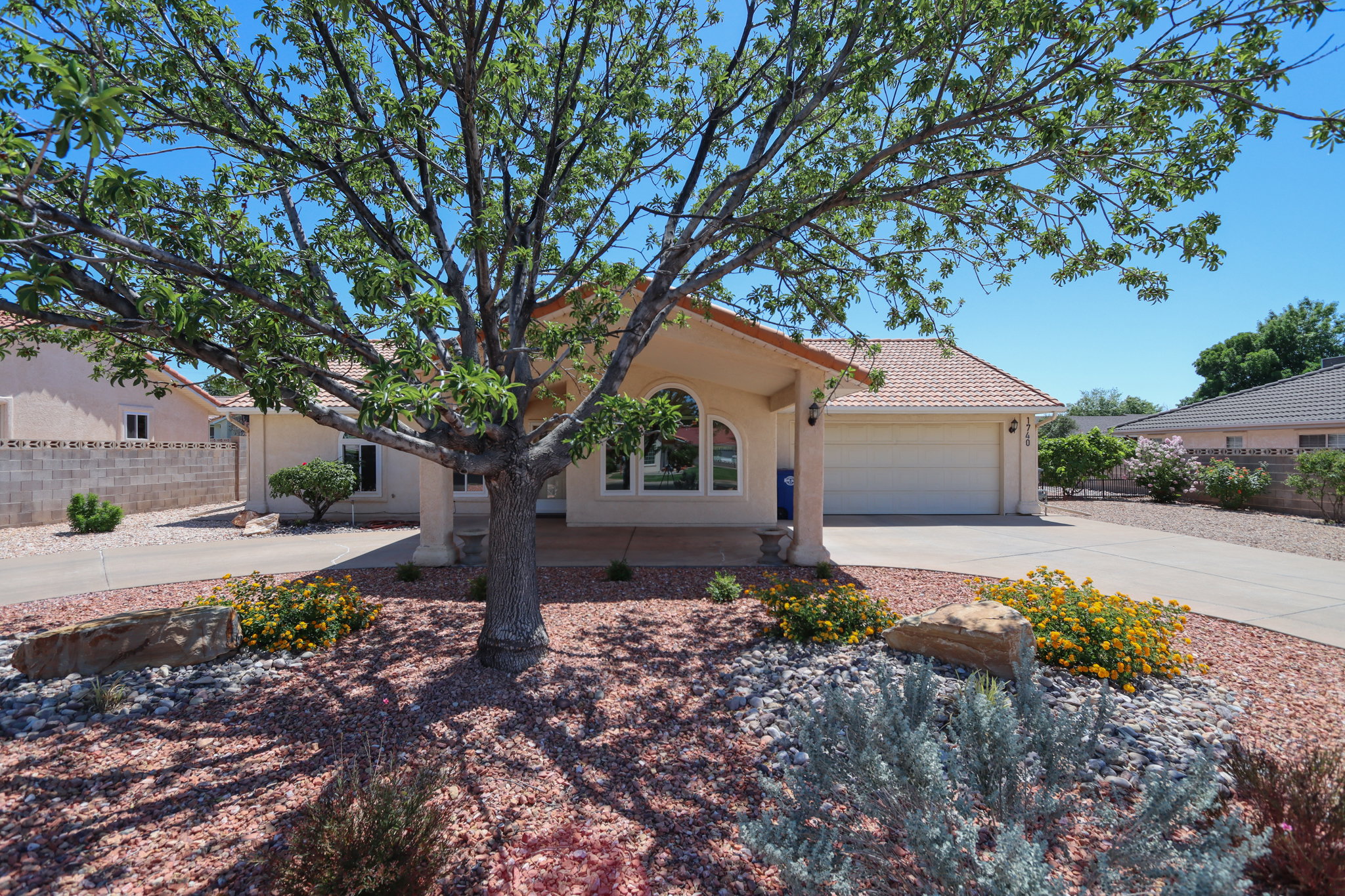 Single-story residence featuring a tile roof, an arched entry, and a two-car garage