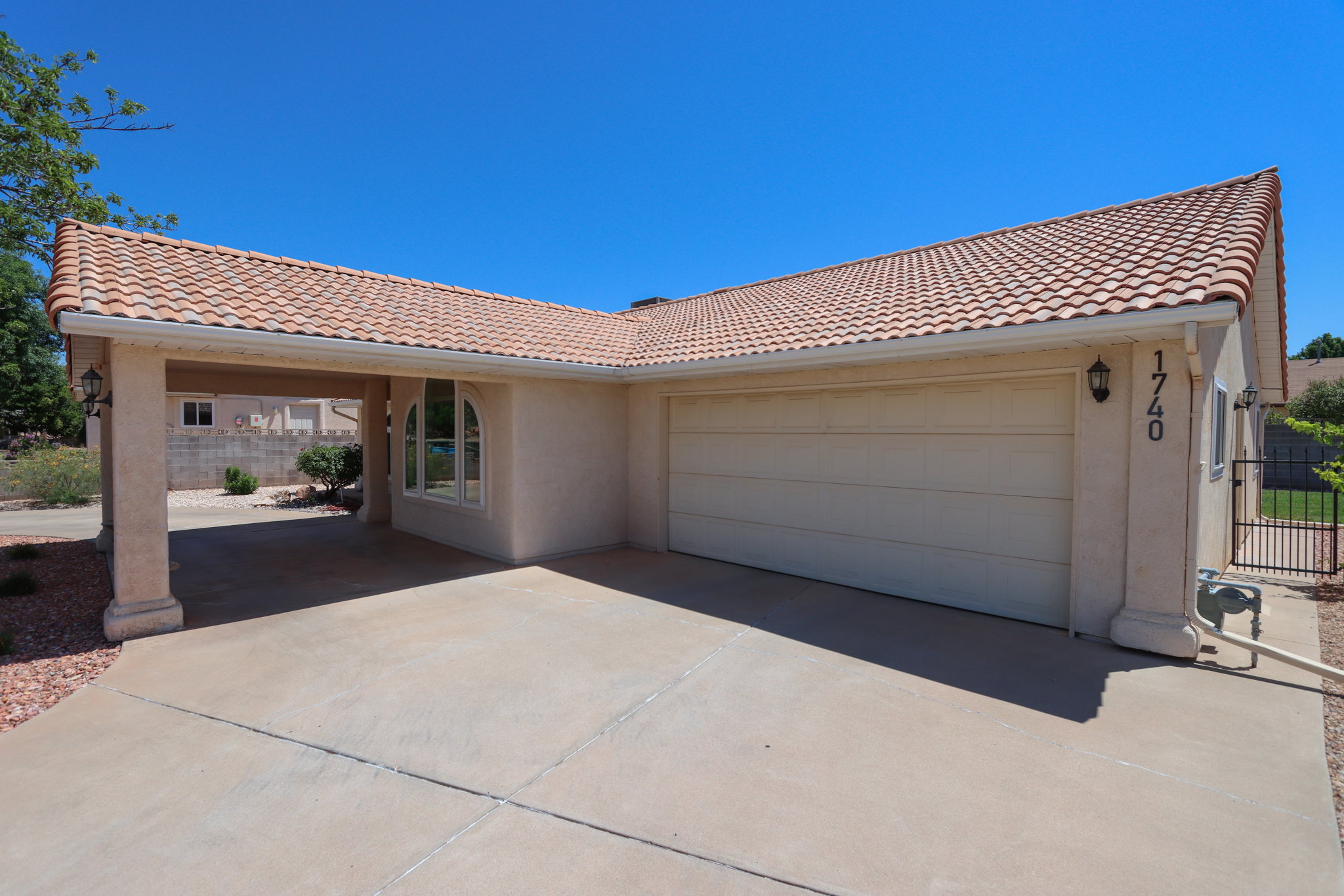 Stucco exterior featuring a tiled roof and an attached two-car garage