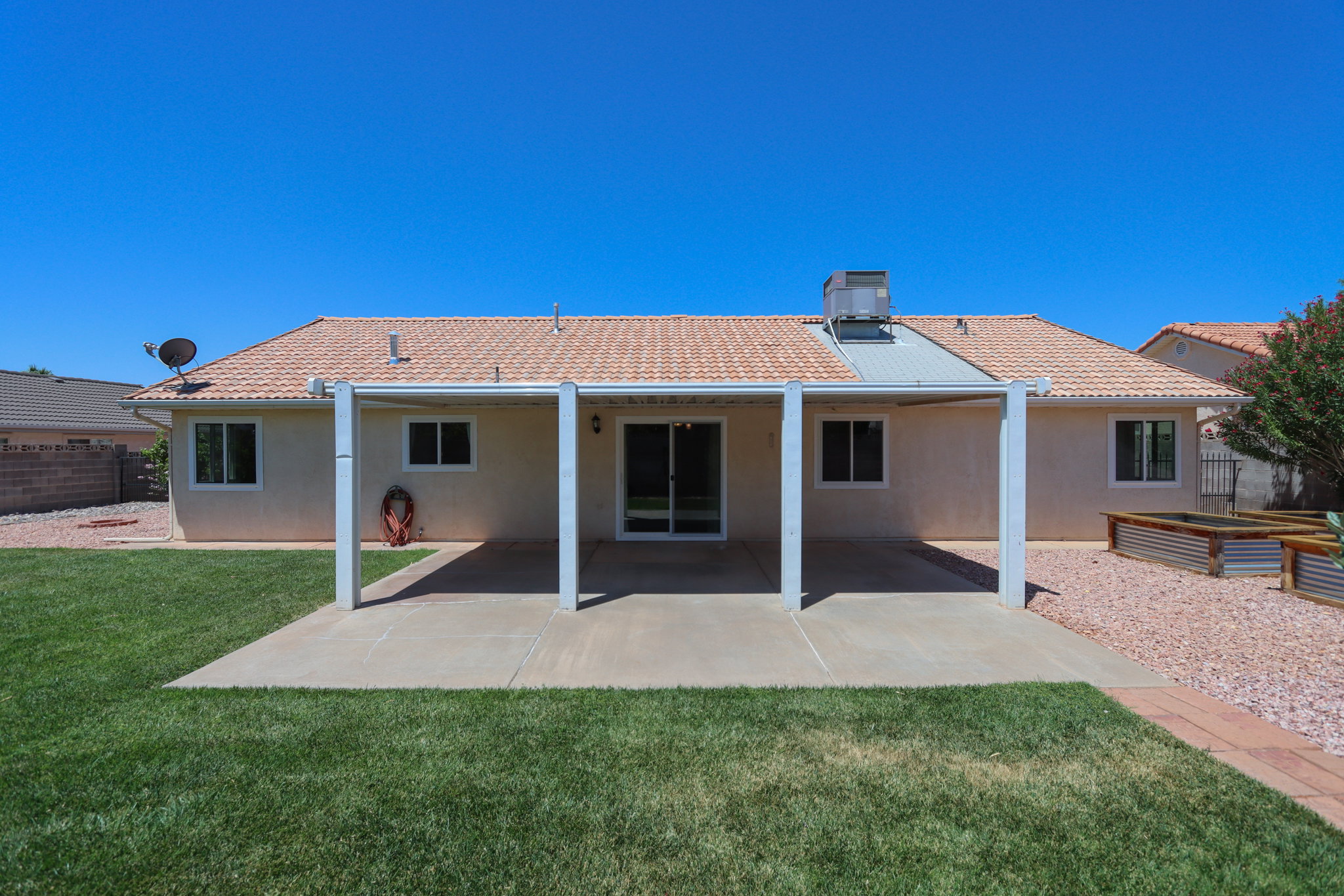 Rear exterior featuring a covered patio, sliding glass door entry, and tile roof