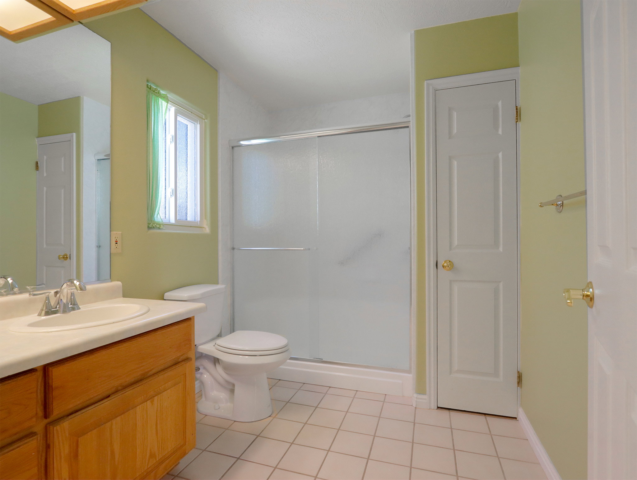 Bathroom featuring a wood-finish vanity with an integrated sink and laminate countertop