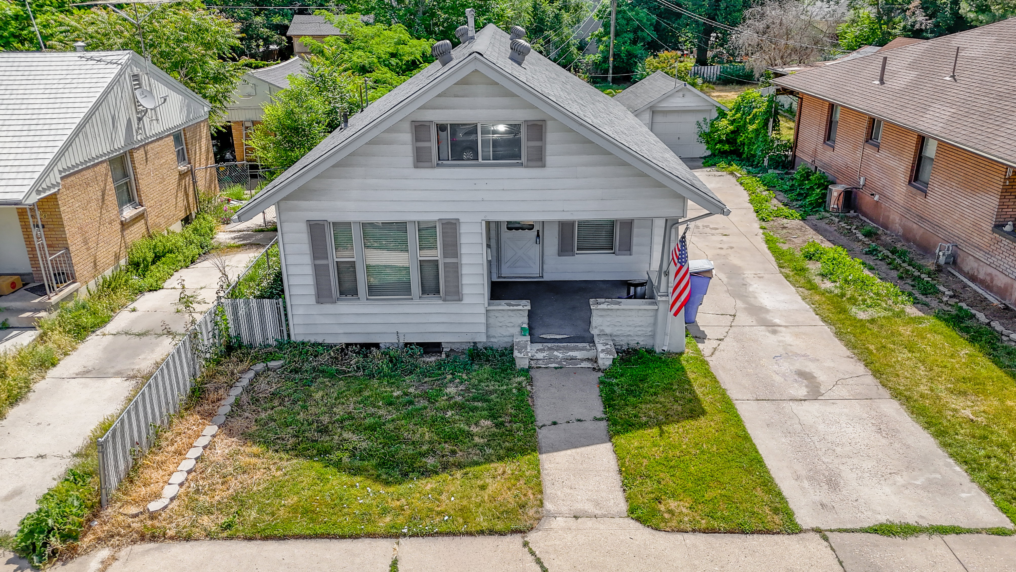 White clapboard siding exterior with a covered front porch and gray shutters