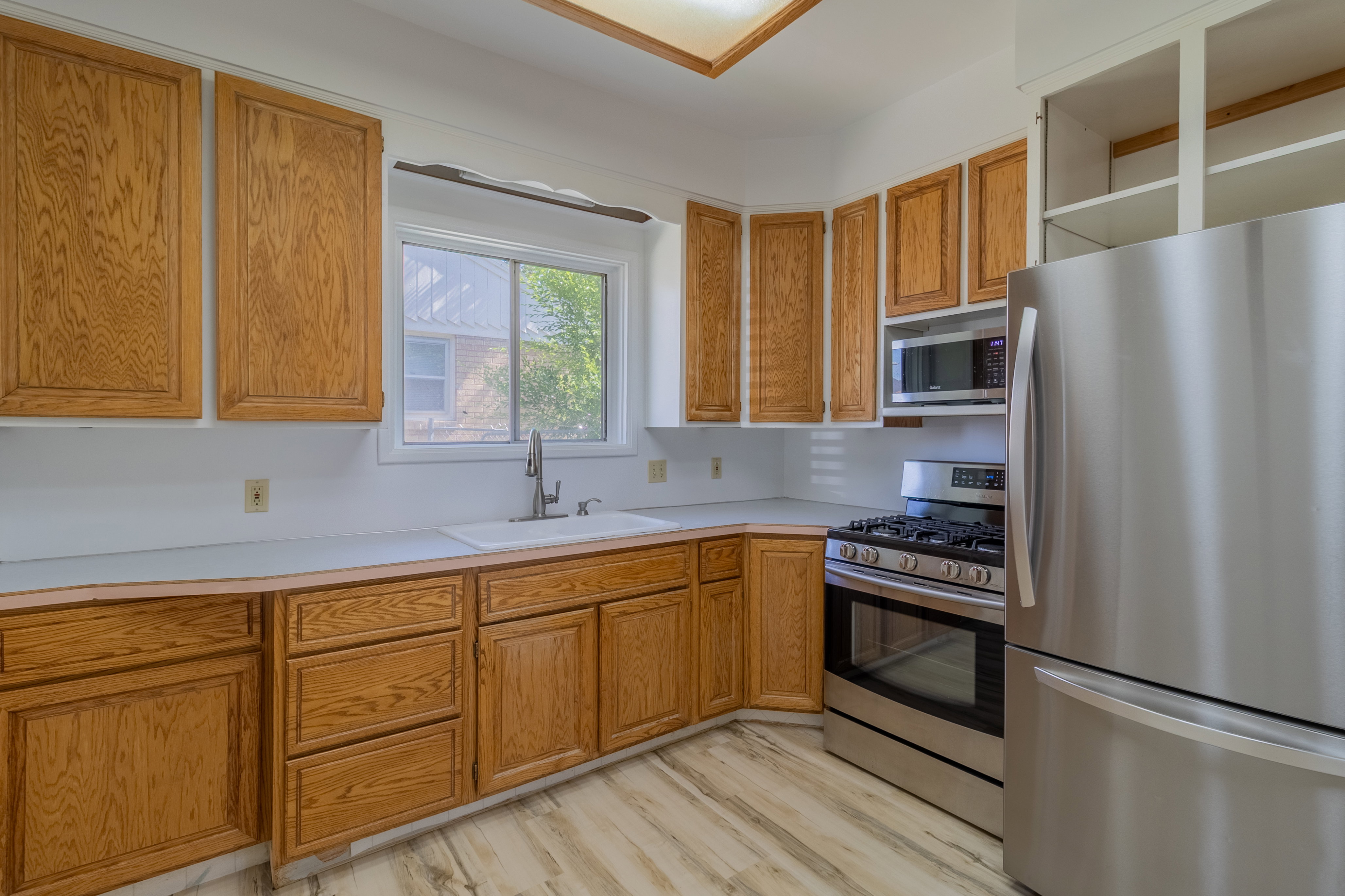 Kitchen featuring wood-finish cabinetry and light-toned countertops