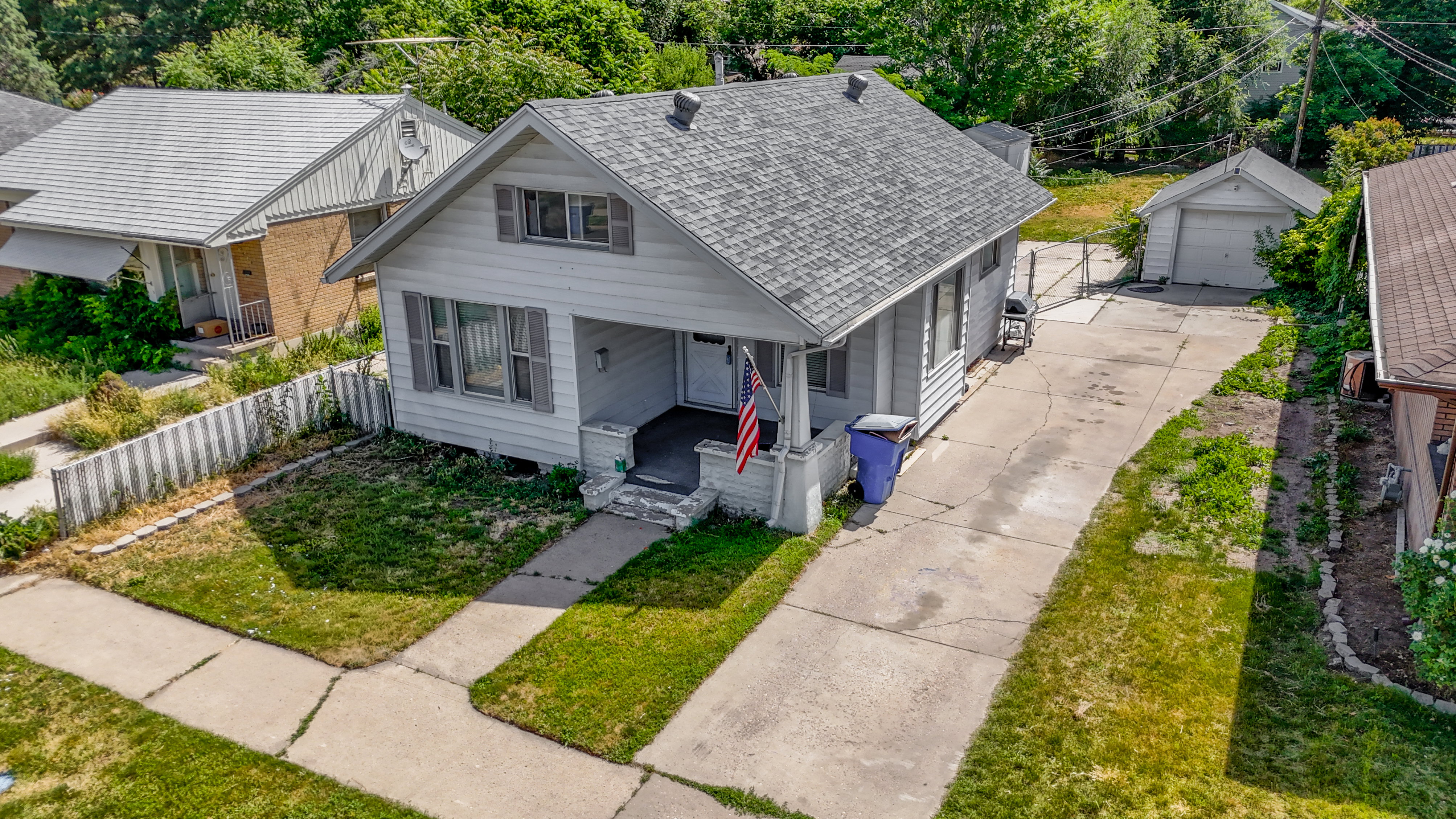 Single-story residence featuring light-colored siding, a covered front porch, and a gray shingle roof
