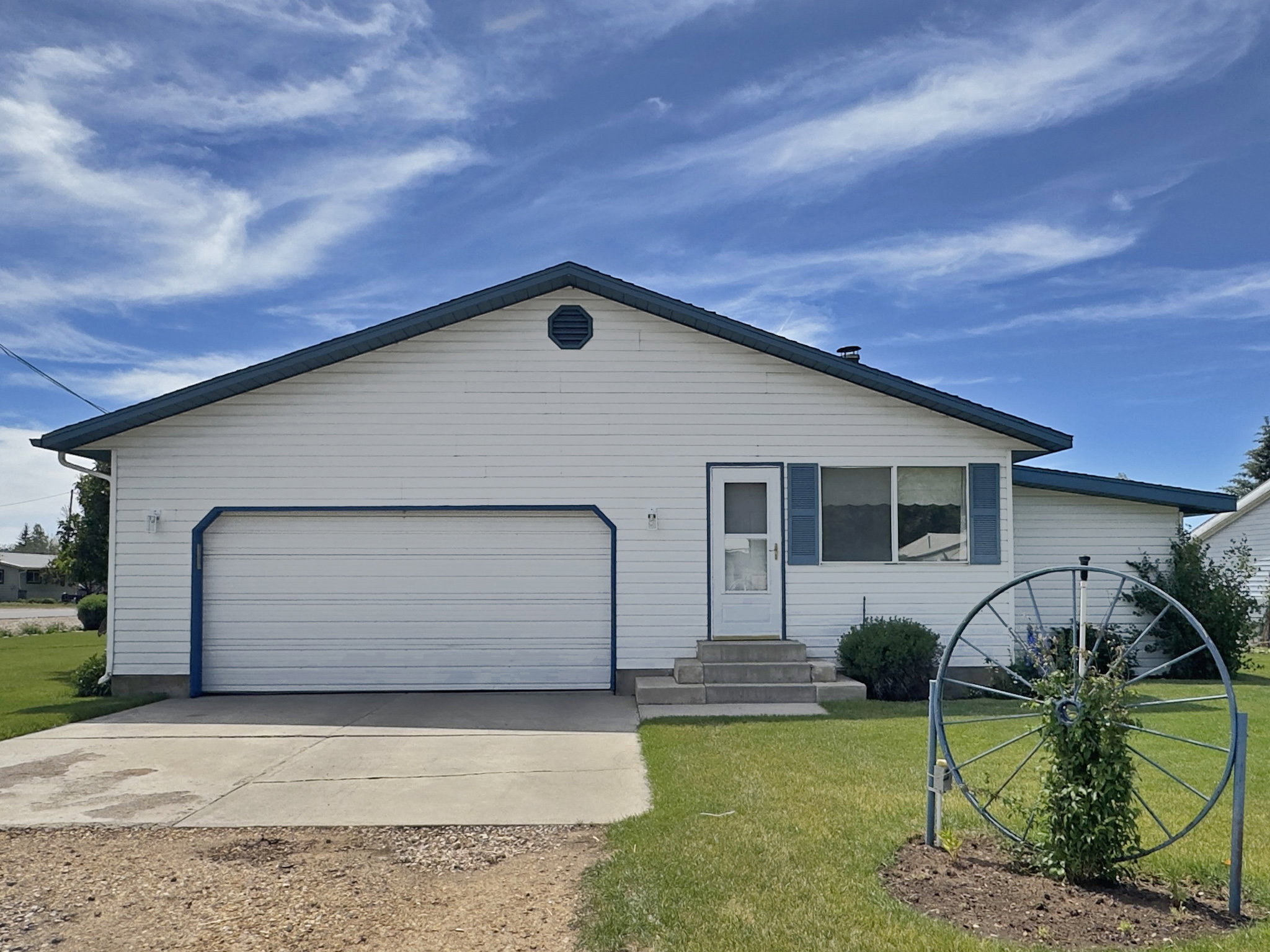 Single-story residence featuring white siding and a contrasting dark blue roofline