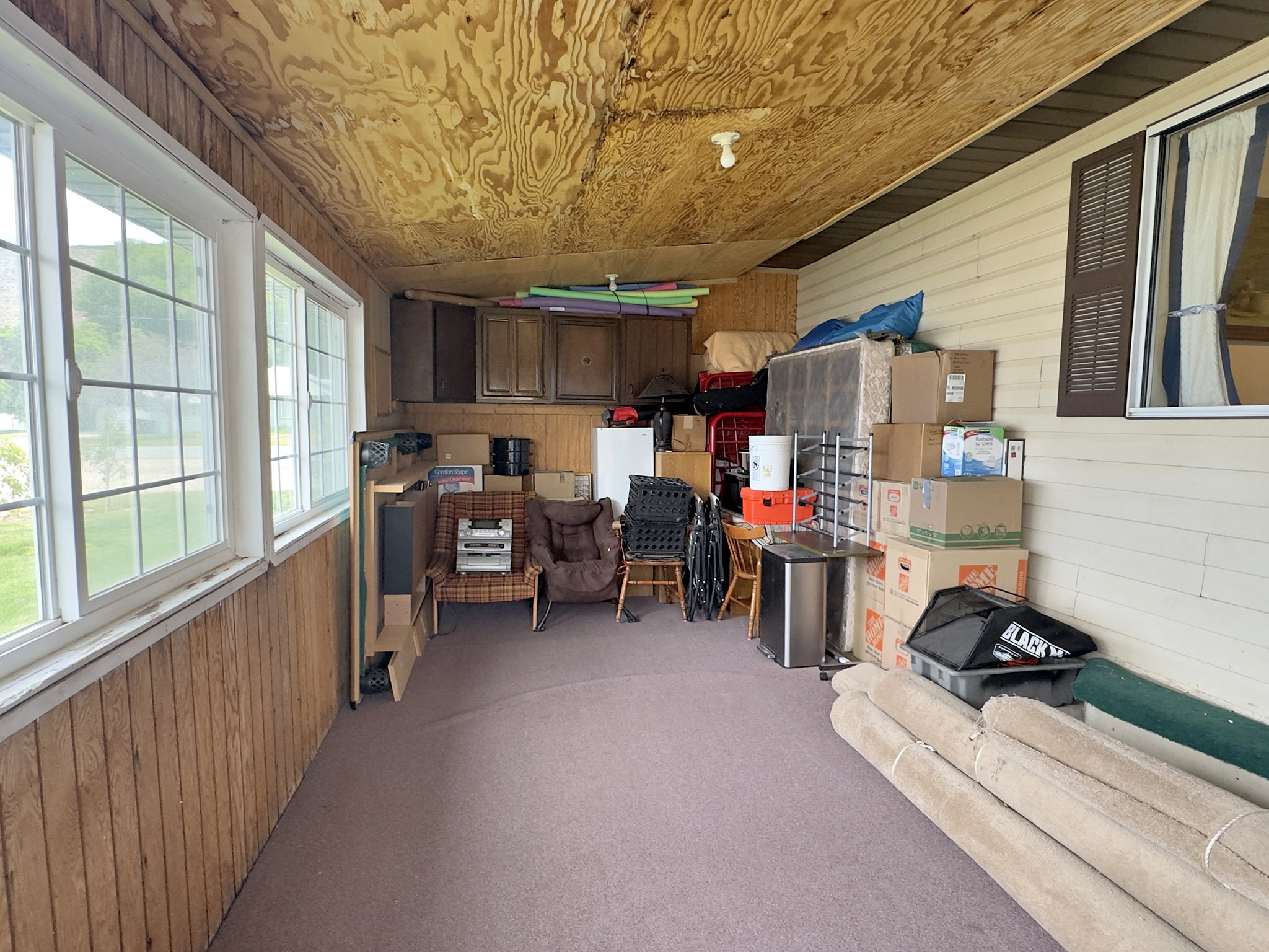 Enclosed porch featuring multiple large windows, wood-paneled walls, and a wood-finish ceiling