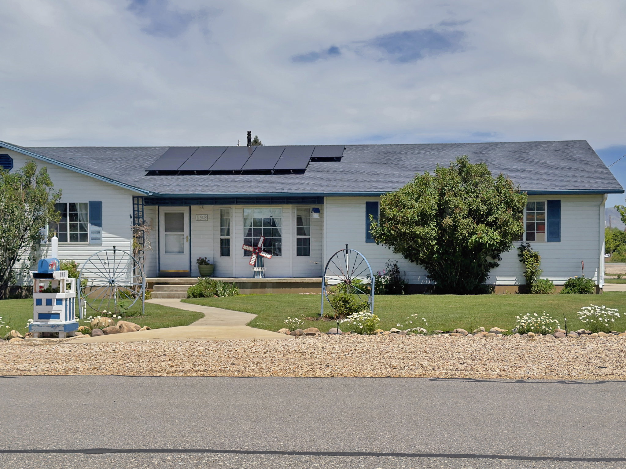White-sided residence featuring a blue shingle roof and solar panels