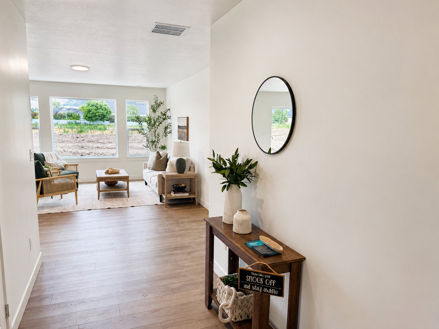 Spacious living area featuring large windows, wood-finish flooring, and recessed ceiling lighting