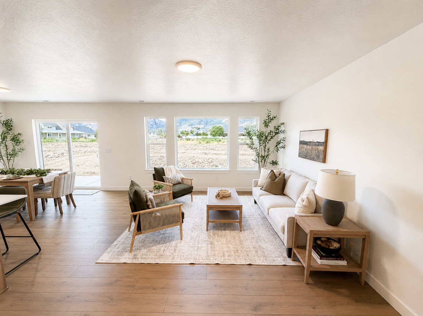Open-concept living area featuring wood-finish flooring, recessed lighting, and large windows