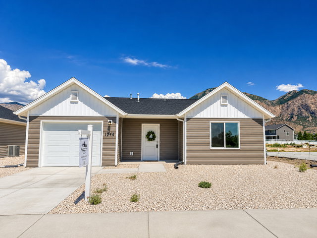 Single-story home featuring a two-tone exterior with horizontal brown siding and white gables