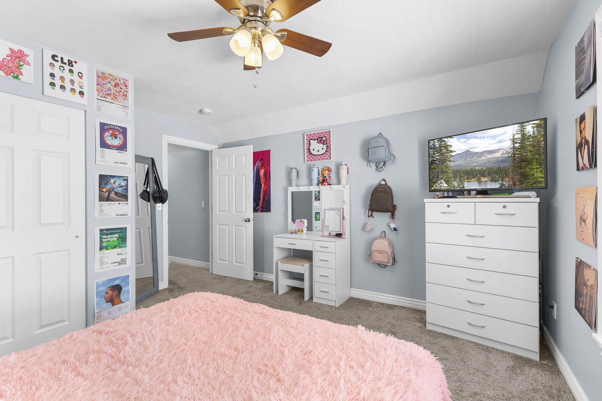 Carpeted bedroom featuring a ceiling fan with integrated lighting, two-panel interior doors, and light blue wall paint