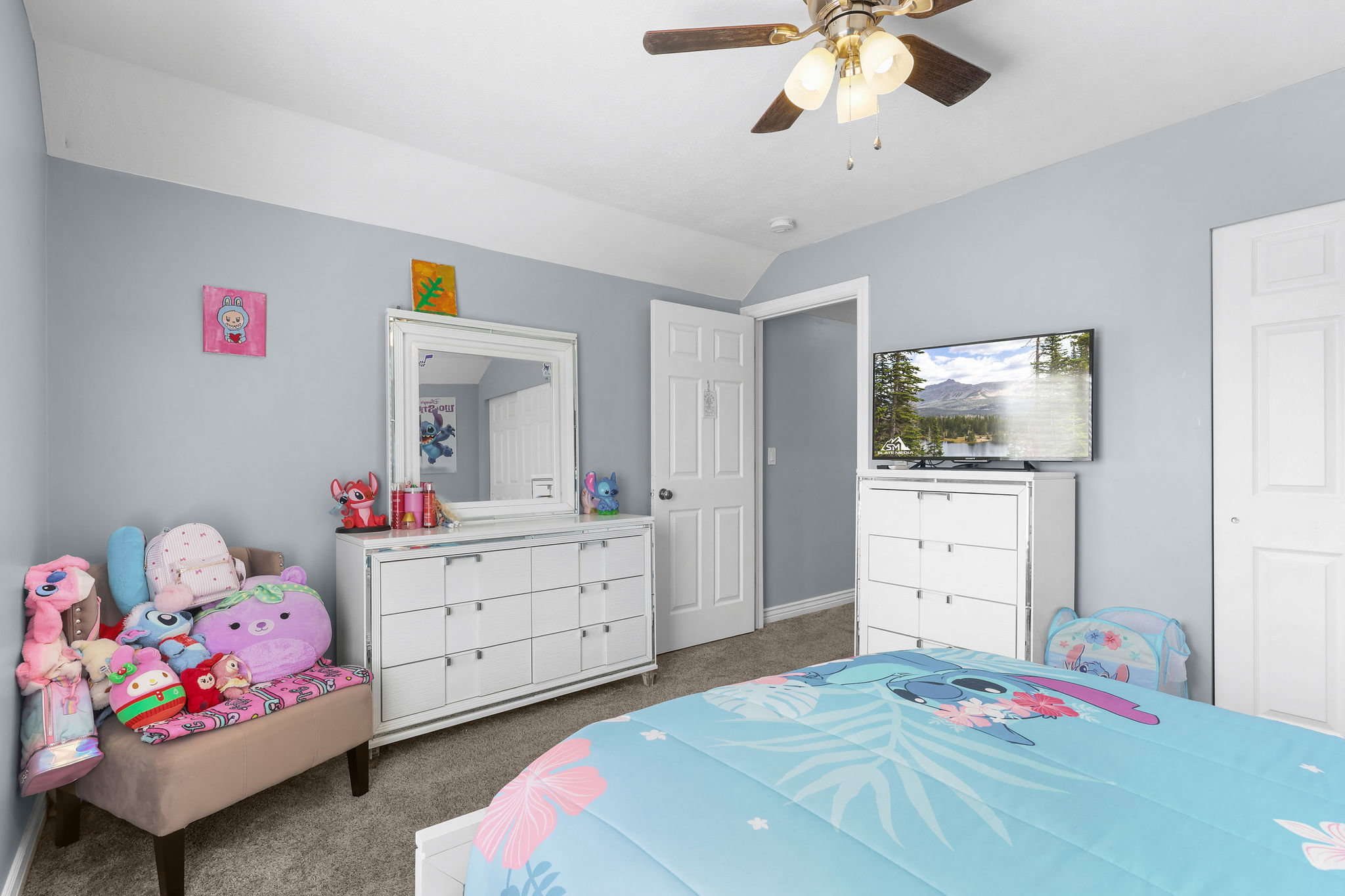 Carpeted room featuring light gray walls, white trim, and a ceiling fan with integrated lighting