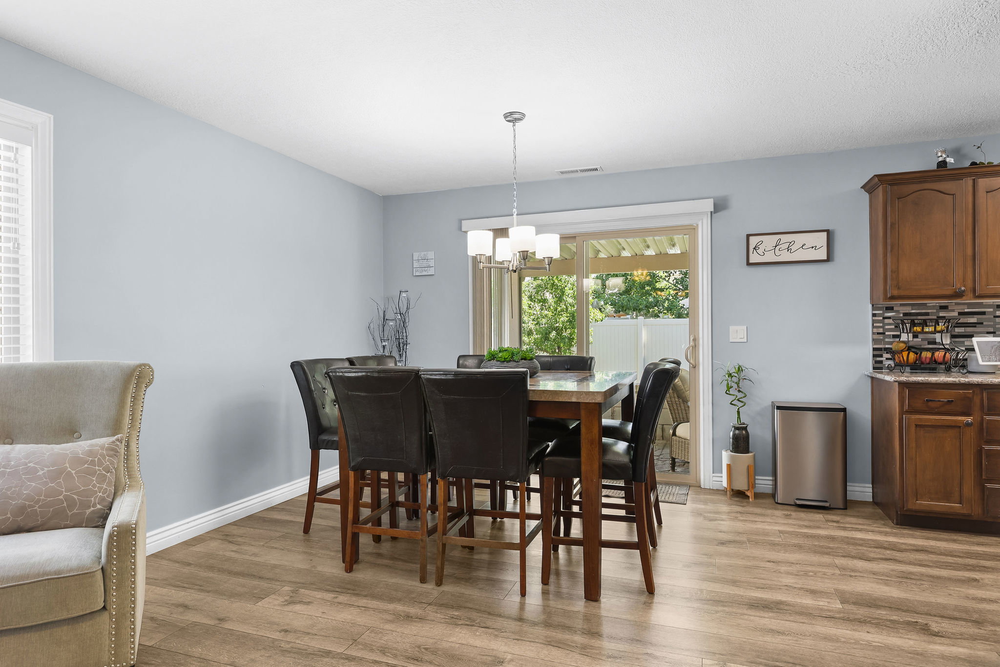 Dining area featuring wood-finish flooring, a contemporary chandelier, and light blue wall paint