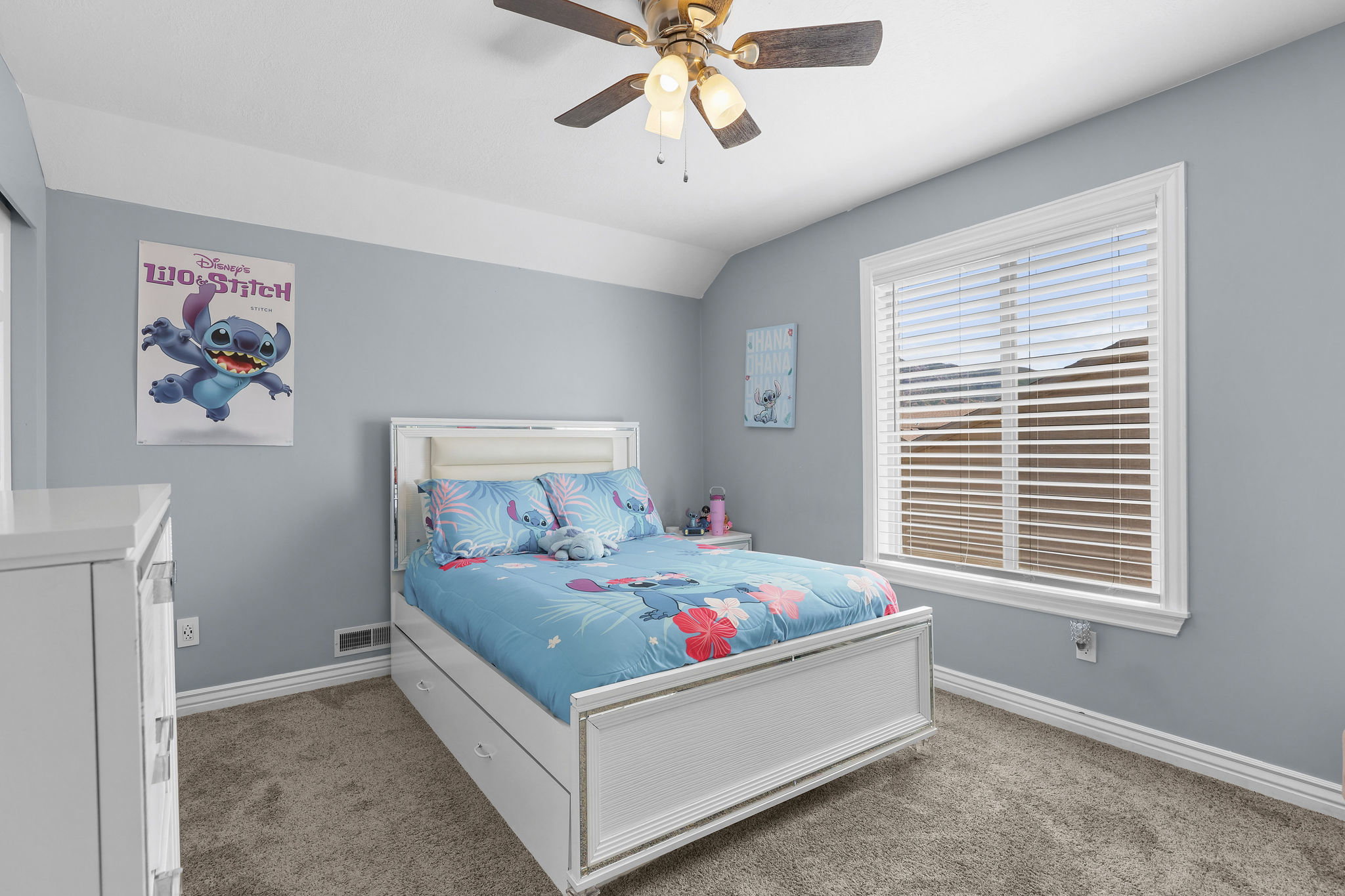 Carpeted room with a ceiling fan, a window with horizontal blinds, and light blue-grey walls