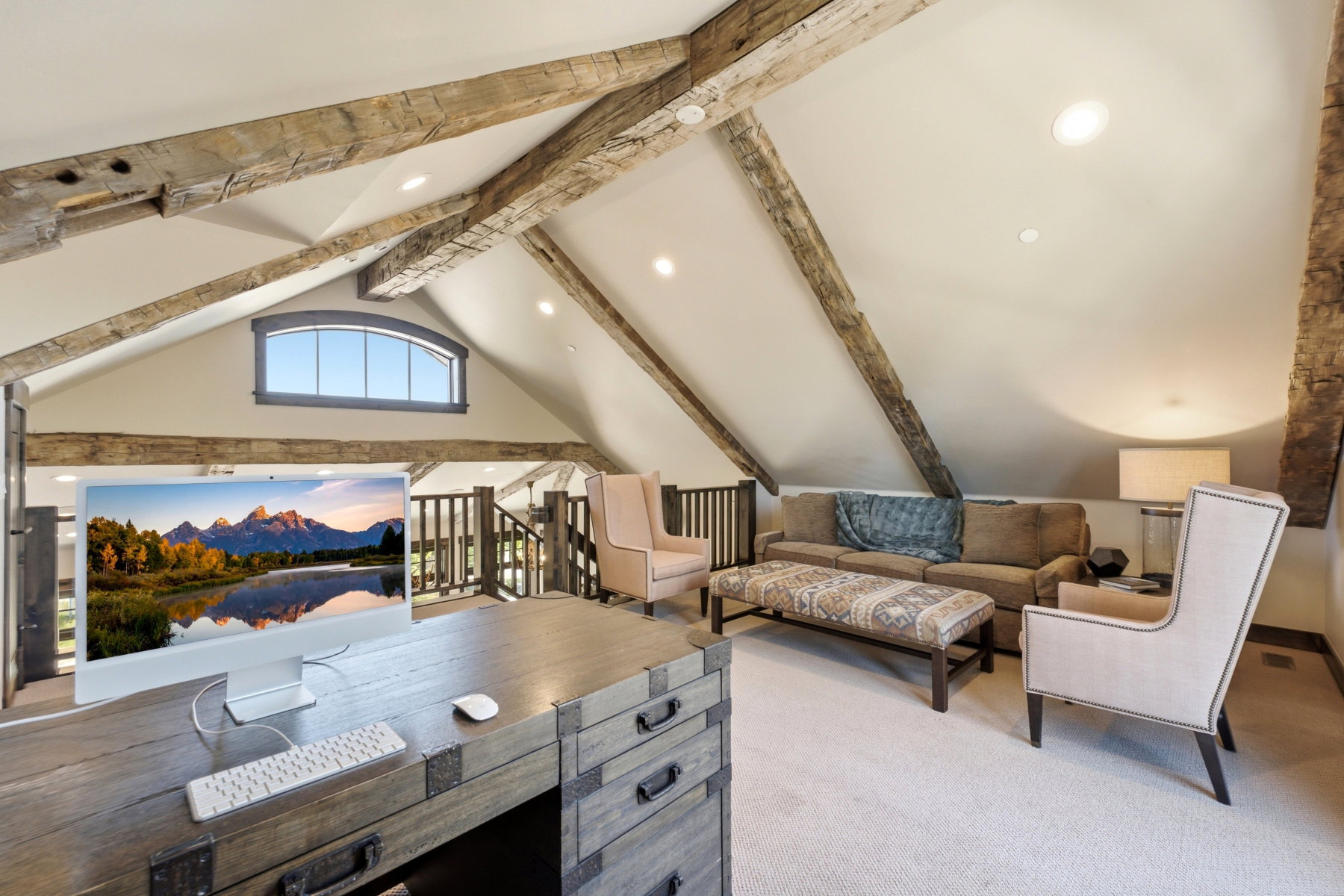 Vaulted ceiling with exposed wood beams, recessed lighting, and an arched window