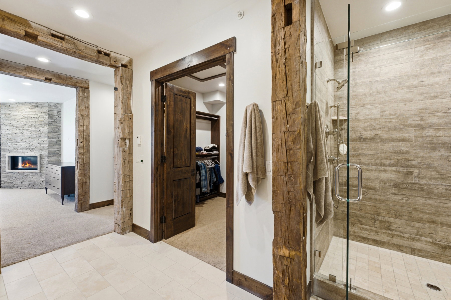 Glass-enclosed shower with subway tile surround and built-in shelving, featuring a rain shower head and separate handheld sprayer
