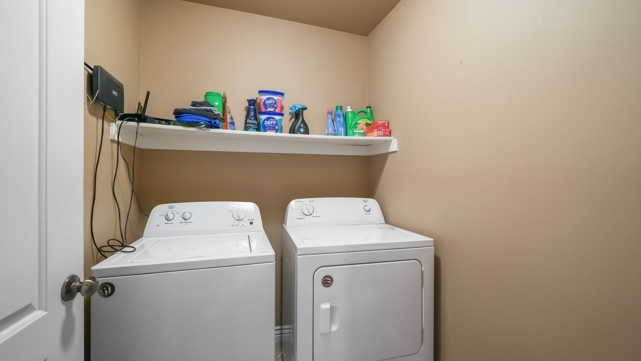 Dedicated laundry area with a white wall-mounted shelf